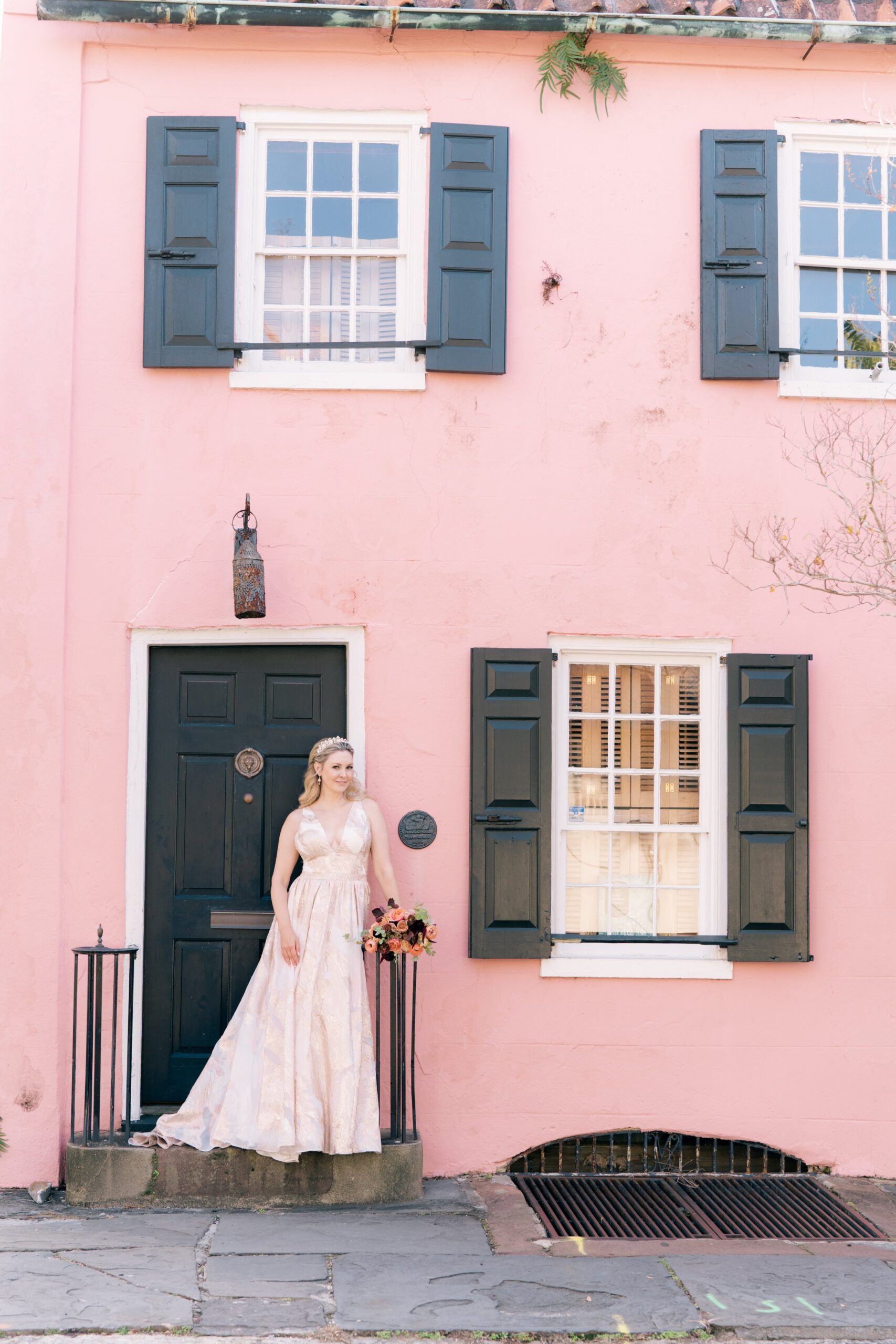 bride in metallic pink dress in front of pink building