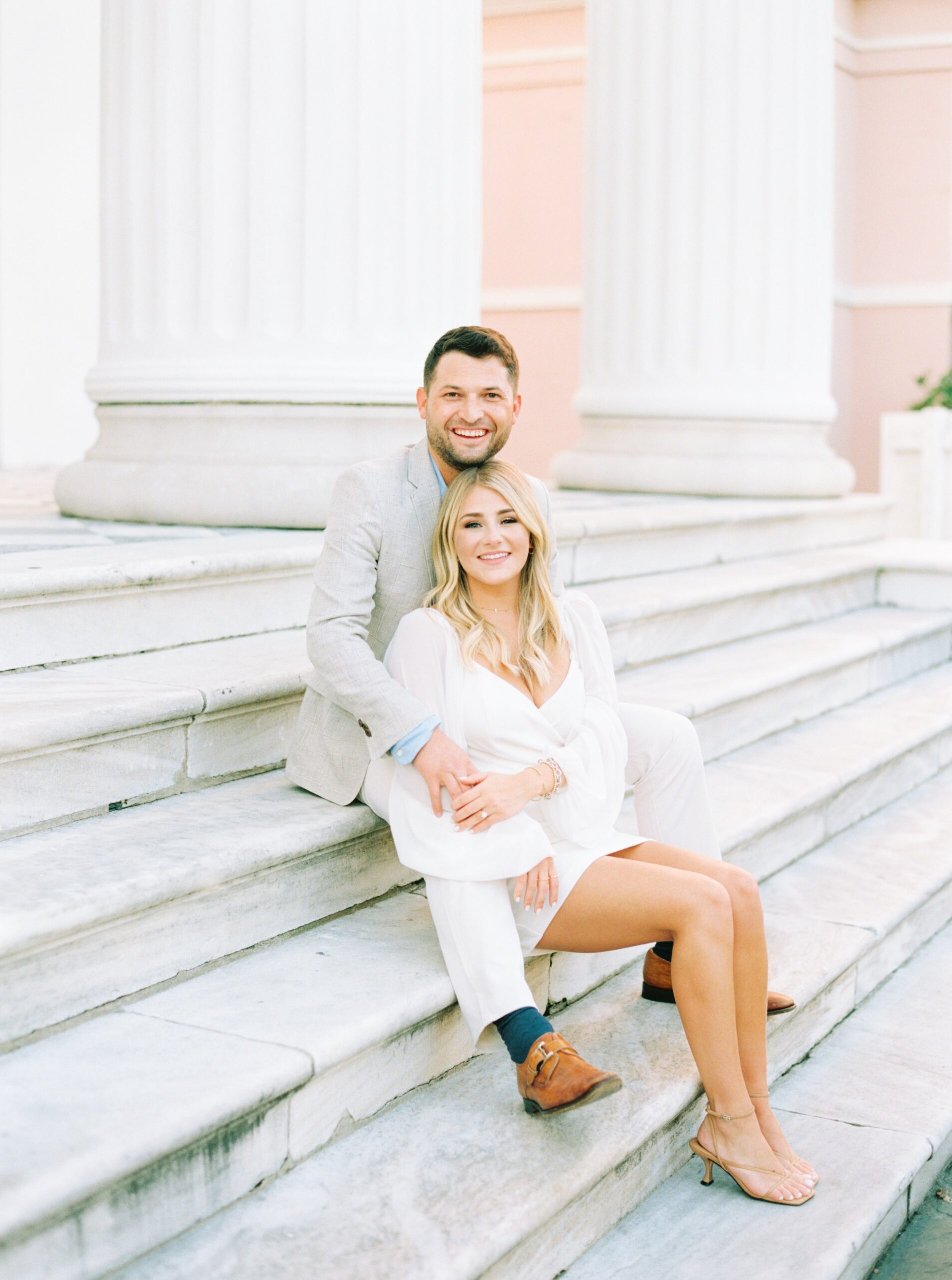 man and woman engagement on marble steps with white columns
