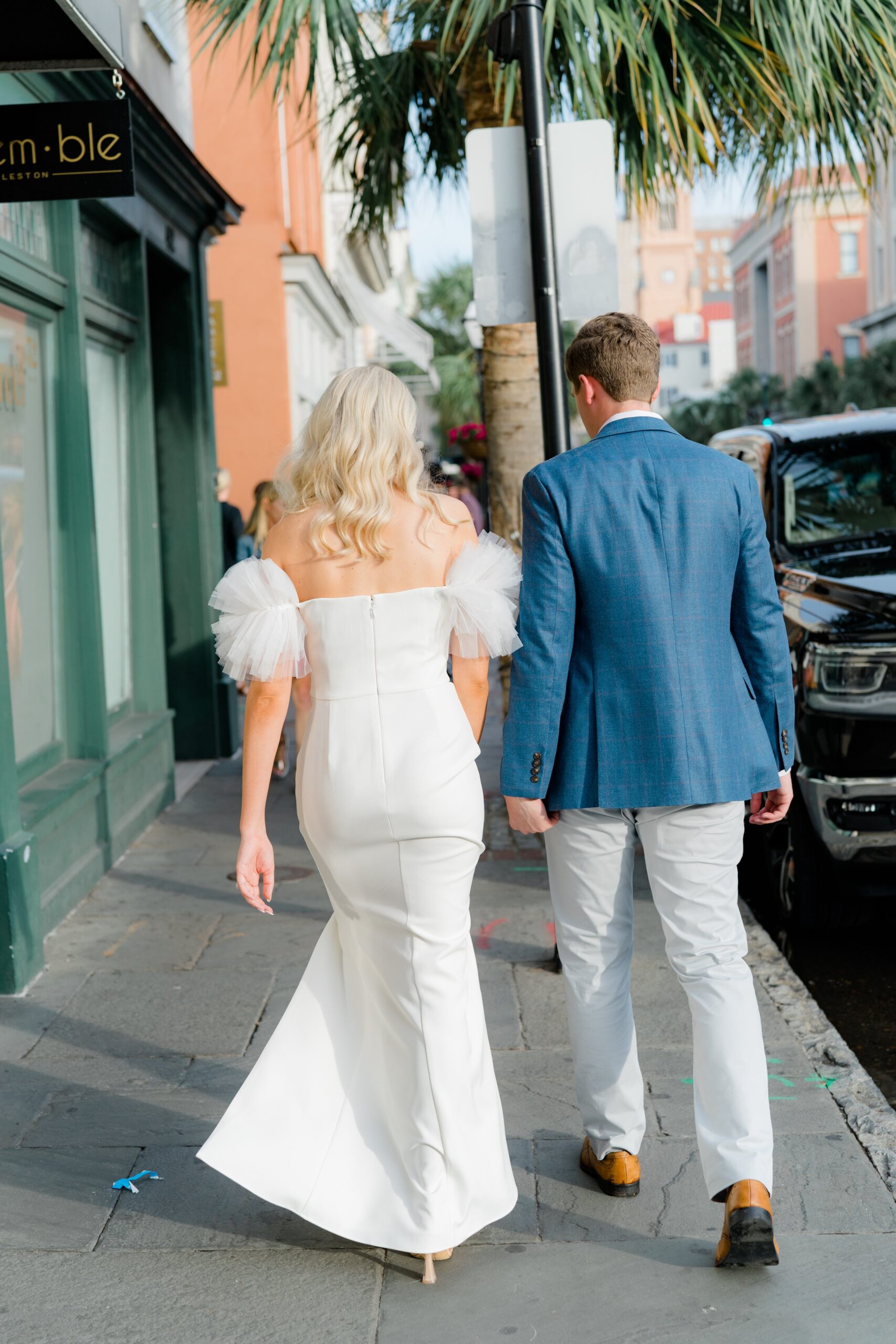 bride and groom walking on the street in downtown Charleston.