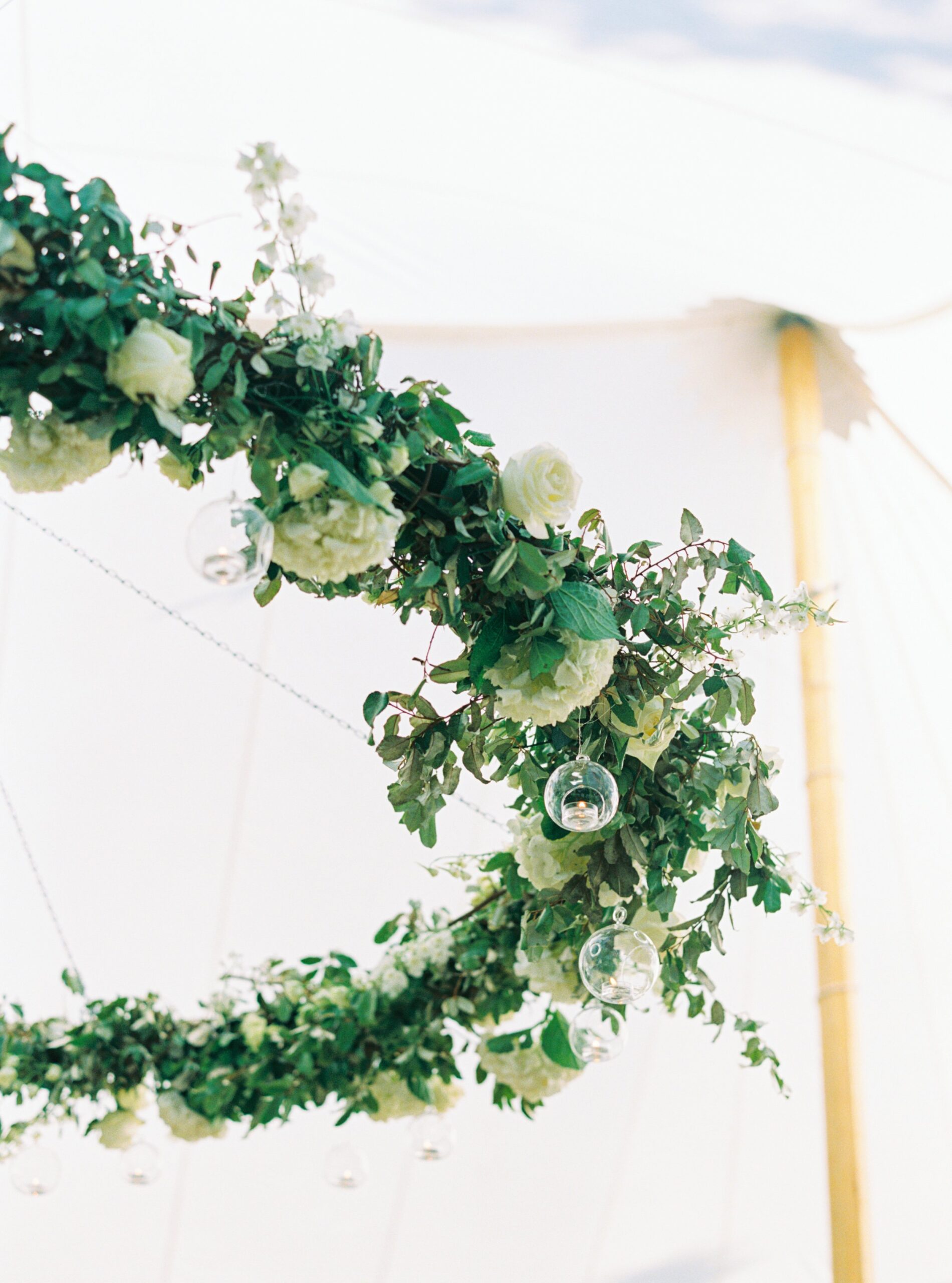 Charleston outdoor spring wedding reception. White flowers and greenery hanging installation.