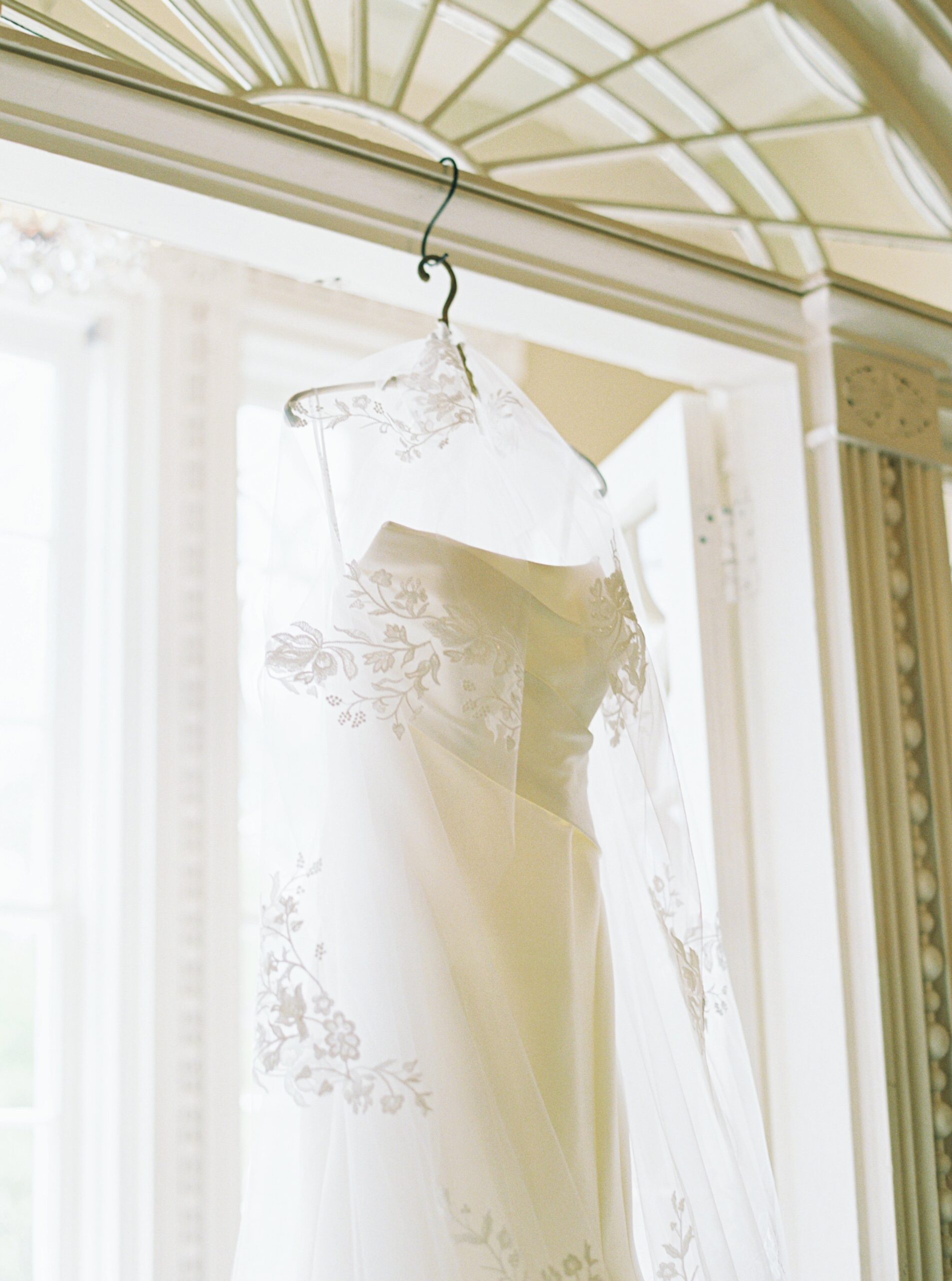 hanging wedding dress and veil with floral details.