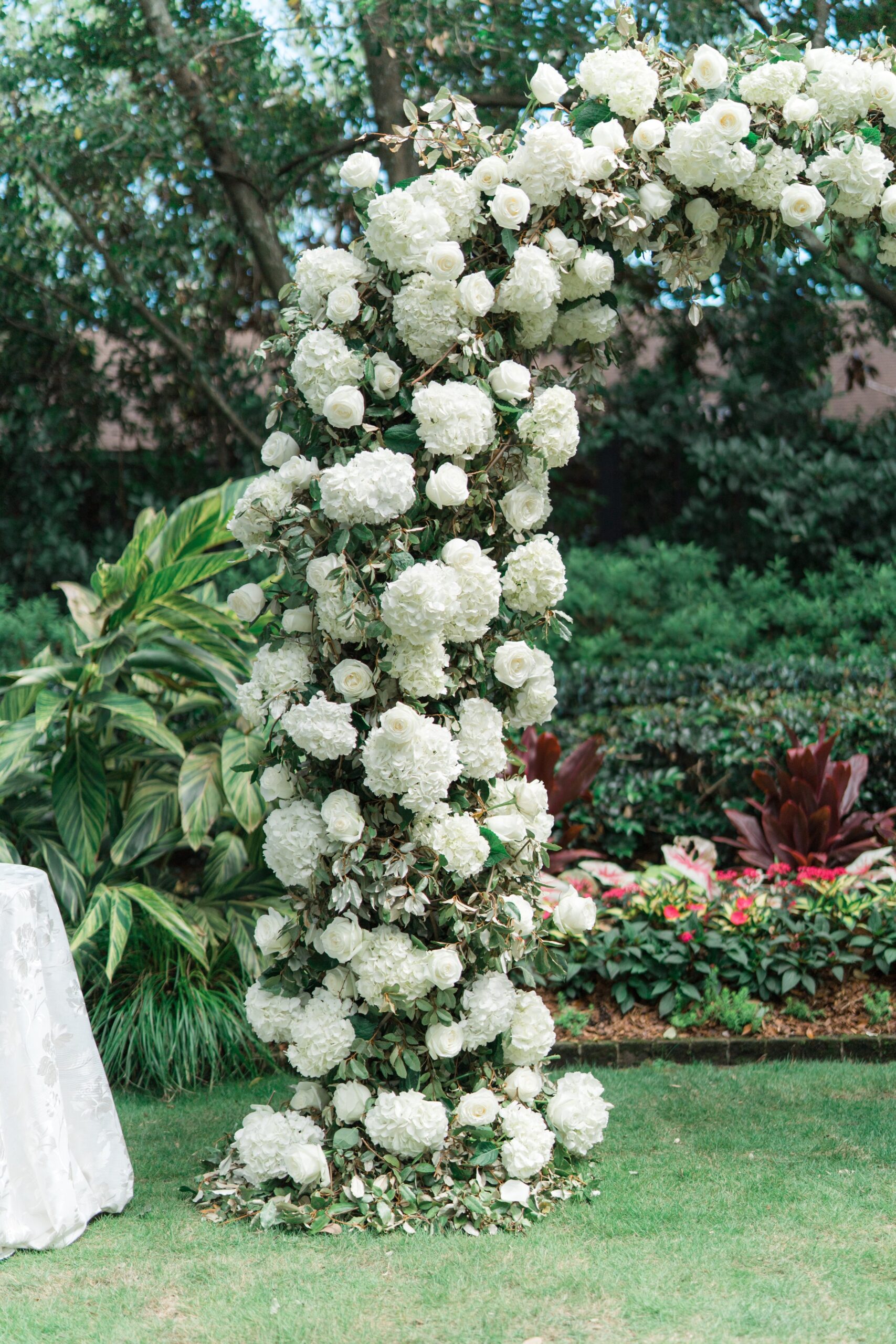 White and green floral arch wedding day detail.