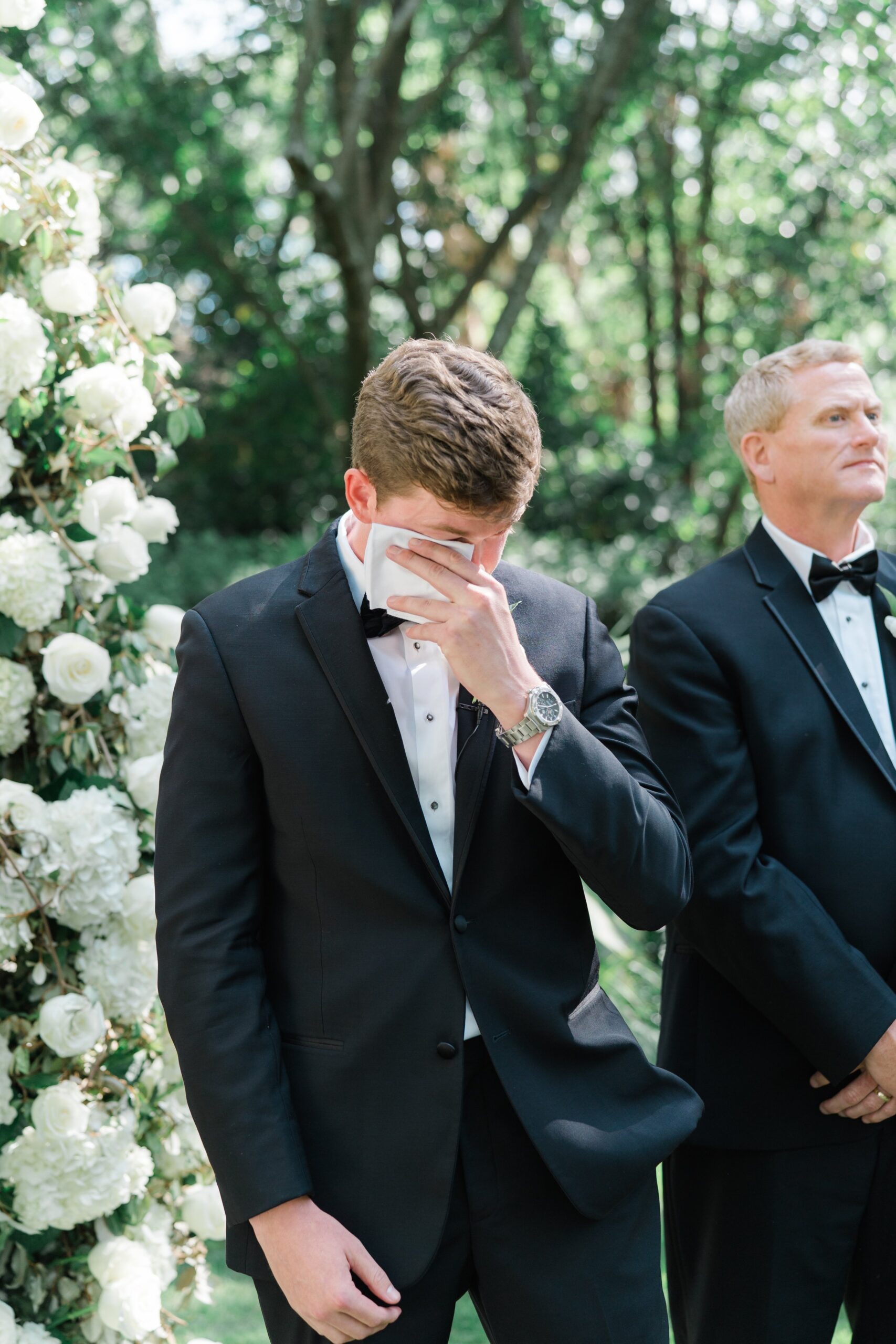 Groom wipes away tears at outdoor wedding ceremony. Governor Thomas Bennett House spring wedding in Charleston. East Coast Destination Wedding Photographer.