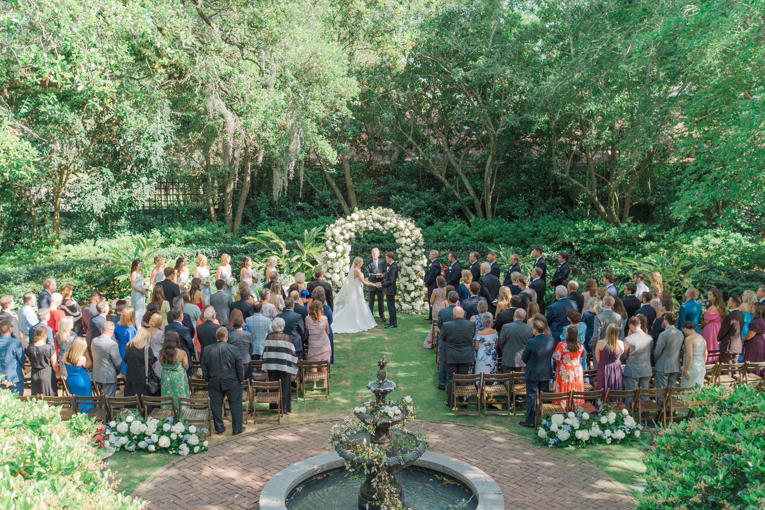 Aerial shot of wedding ceremony. Governor Thomas Bennett House. Large white flower arch. Outdoor spring wedding. Charleston wedding photographer.