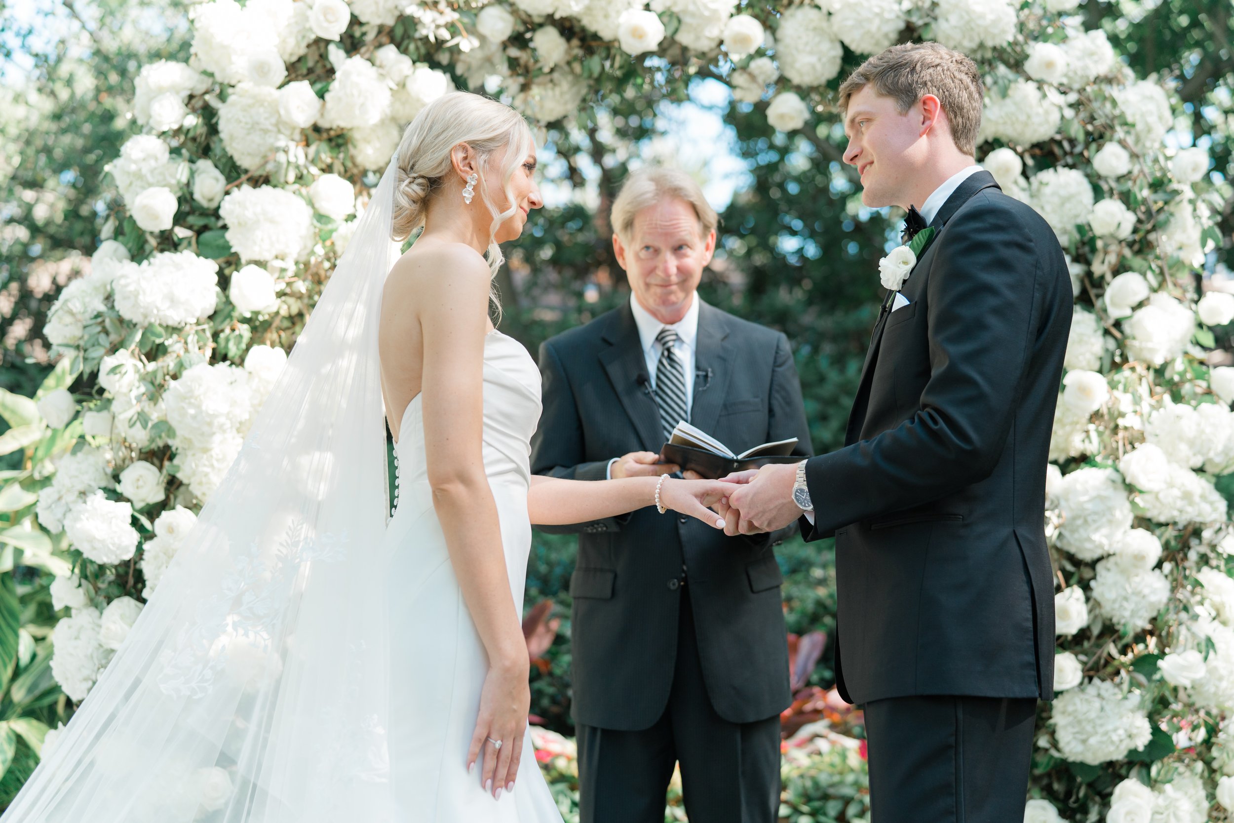 Groom puts ring on bride during outdoor wedding ceremony. Charleston film photographer.