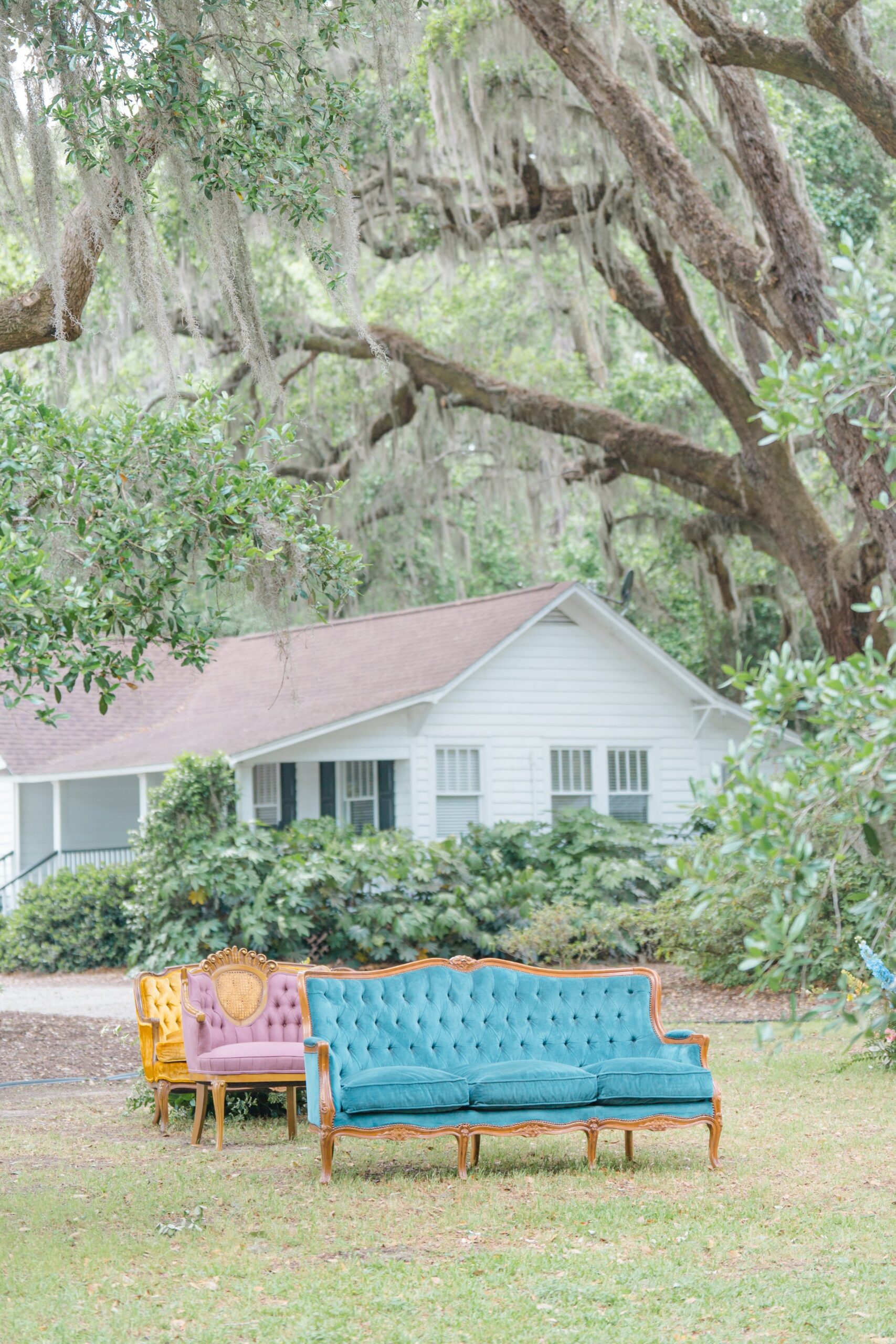 blue vintage couch under live oak trees at spanish moss
