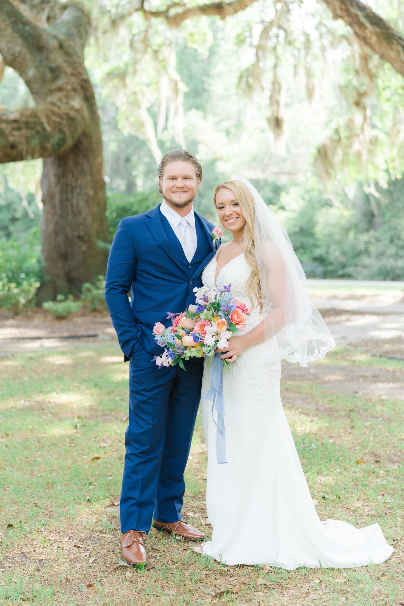 bride and groom standing under spanish moss