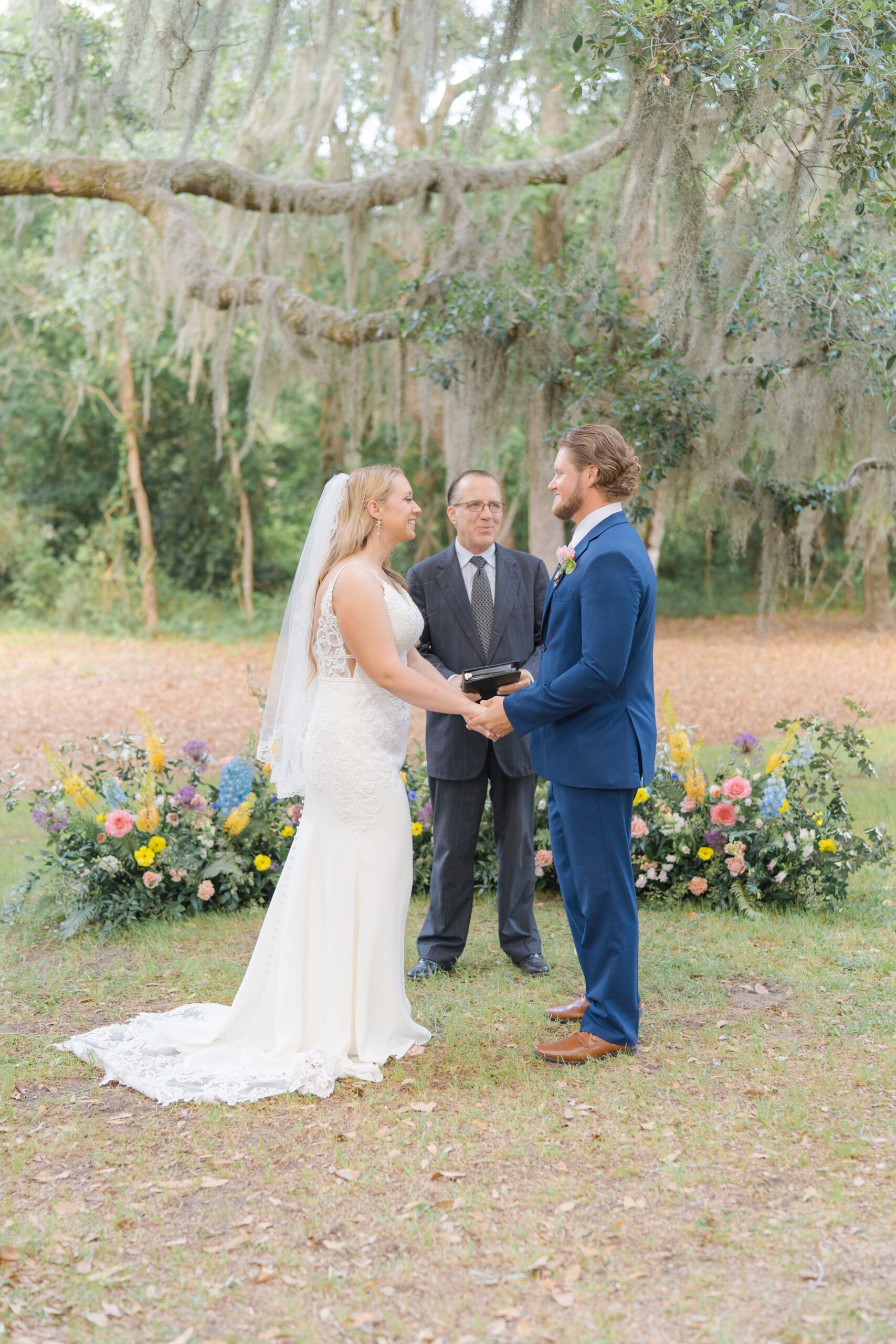 bride and groom smile at each other during intimate spring wedding ceremony
