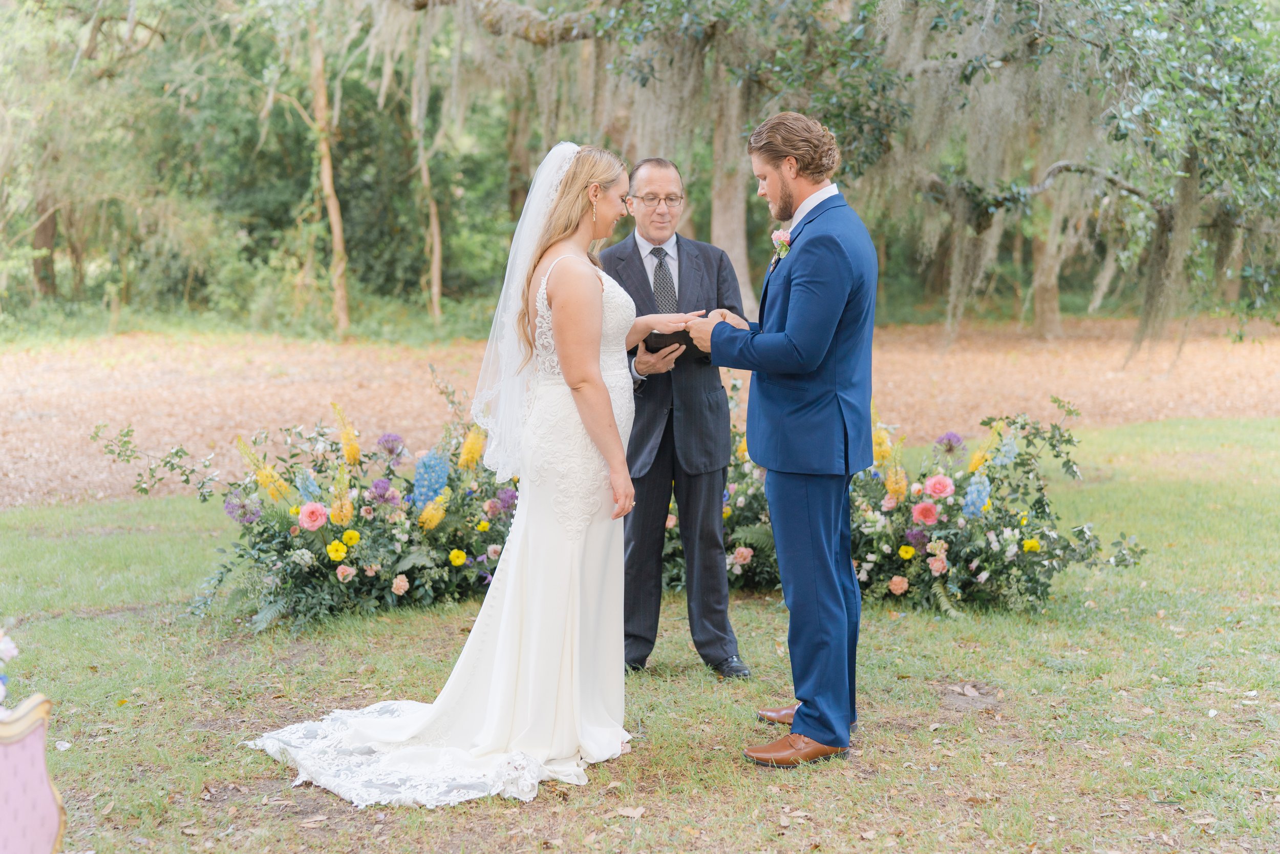 Groom puts ring on brides finger during wedding ceremony
