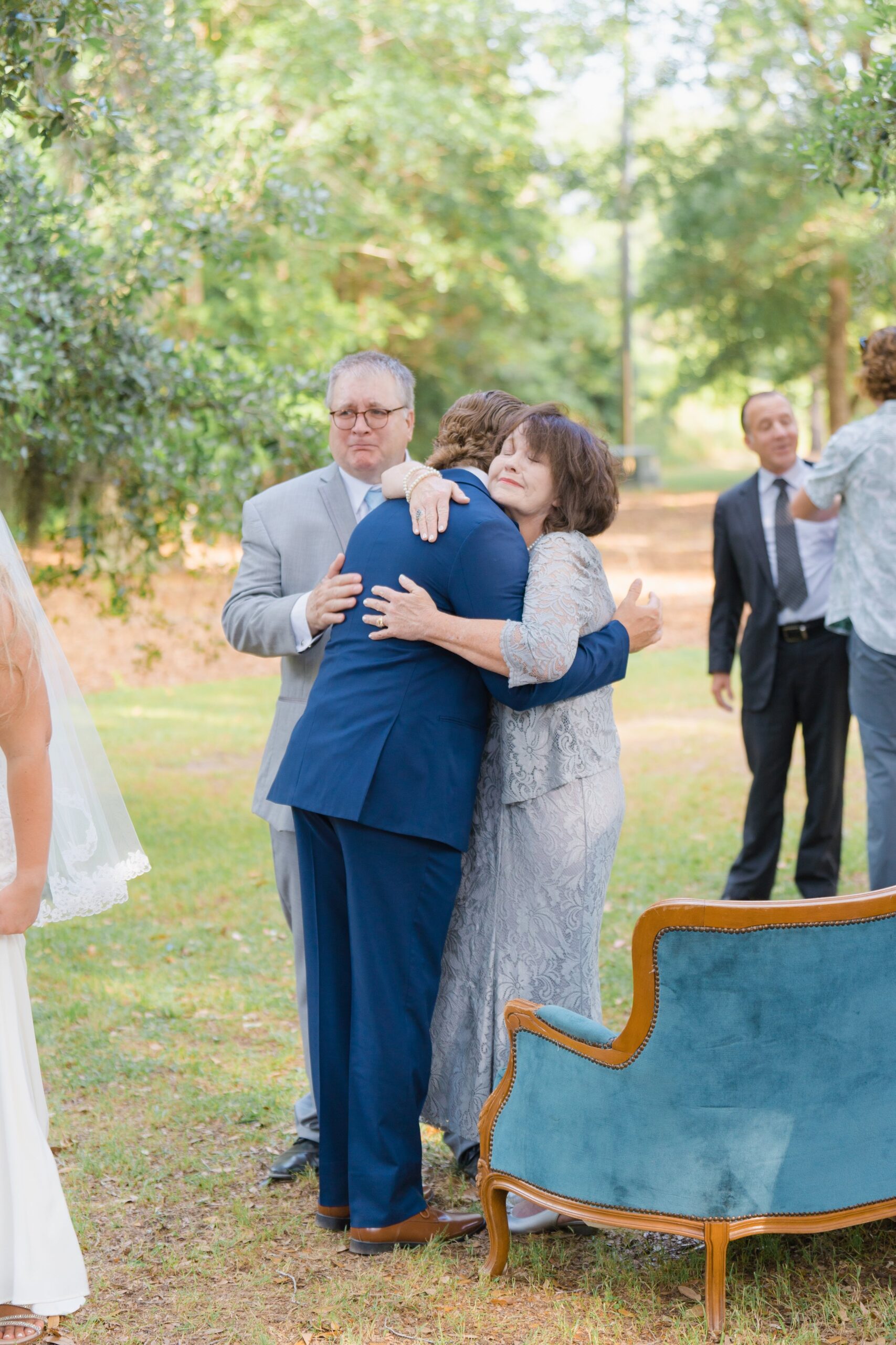 groom shares emotional moment with mom and dad