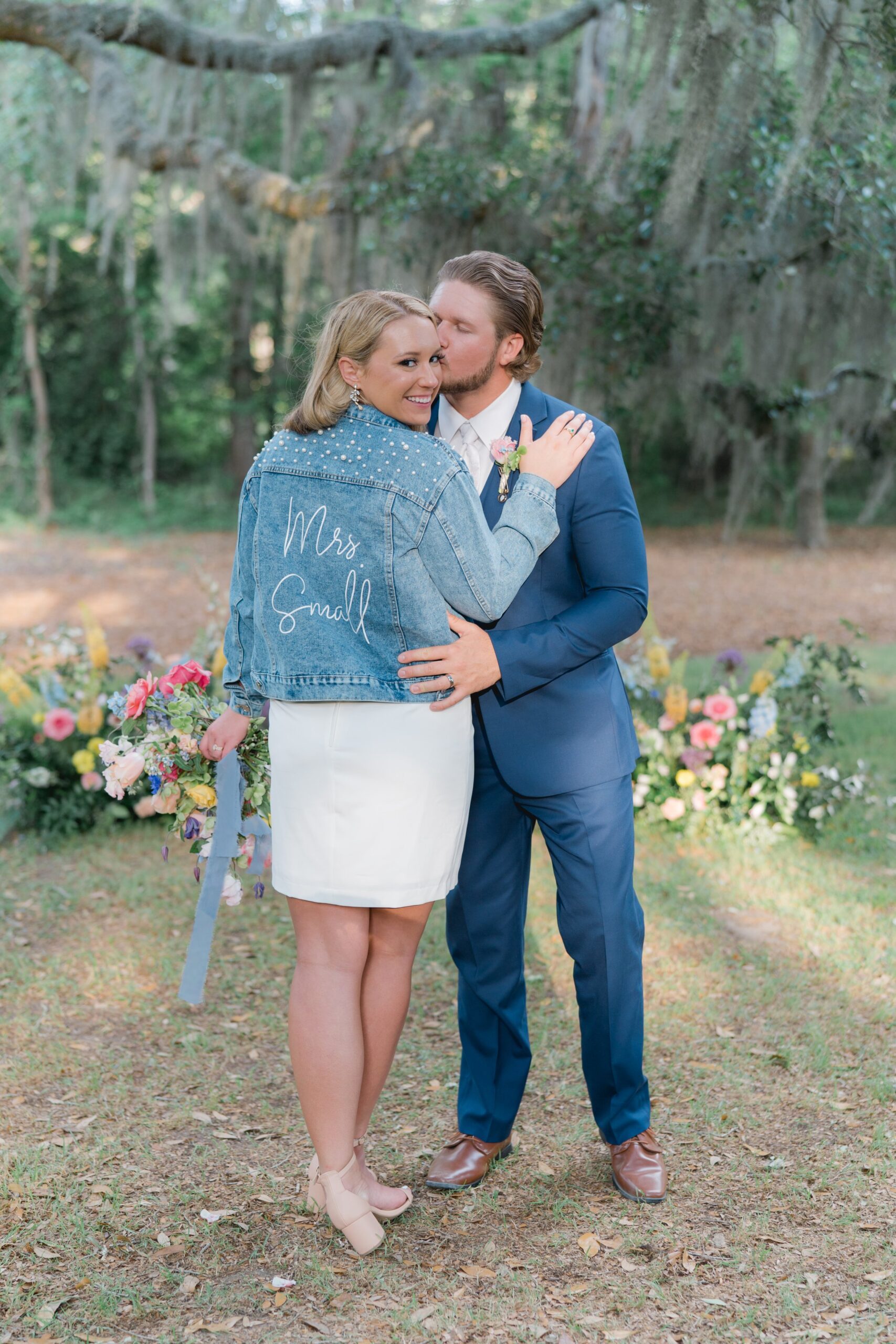bride changes into second dress with custom jean jacket