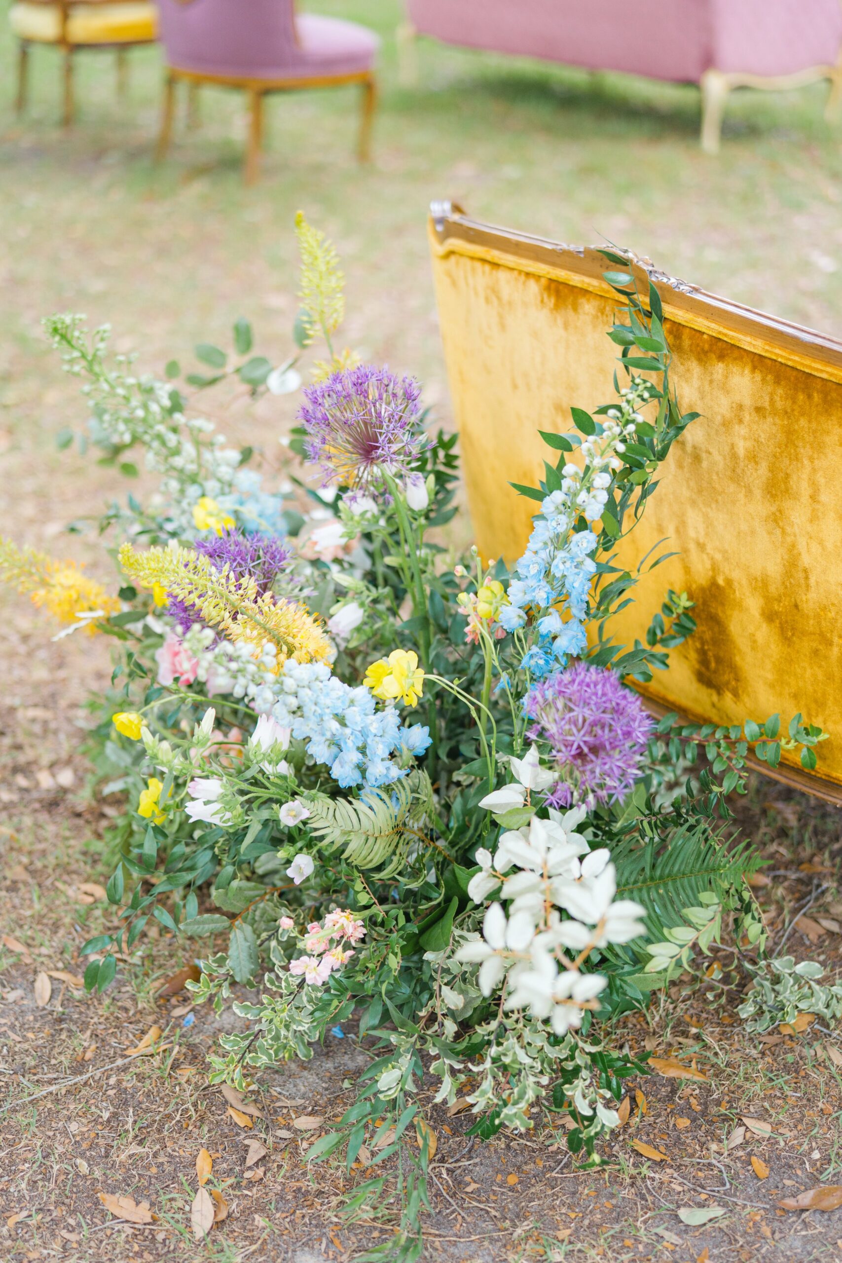 wildflowers and yellow vintage couch seating at wedding ceremony