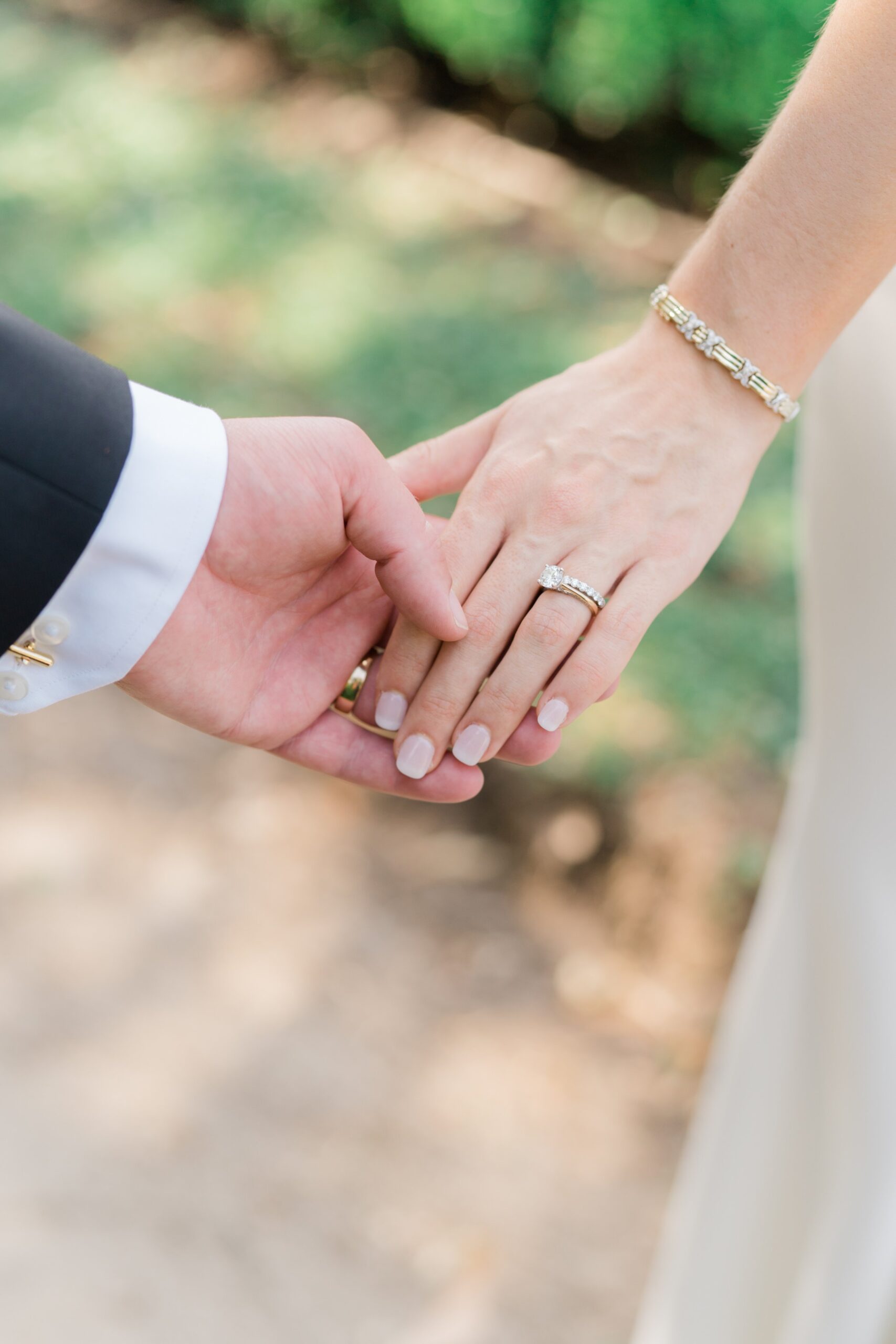 Groom holds brides hand. Wedding ring detail