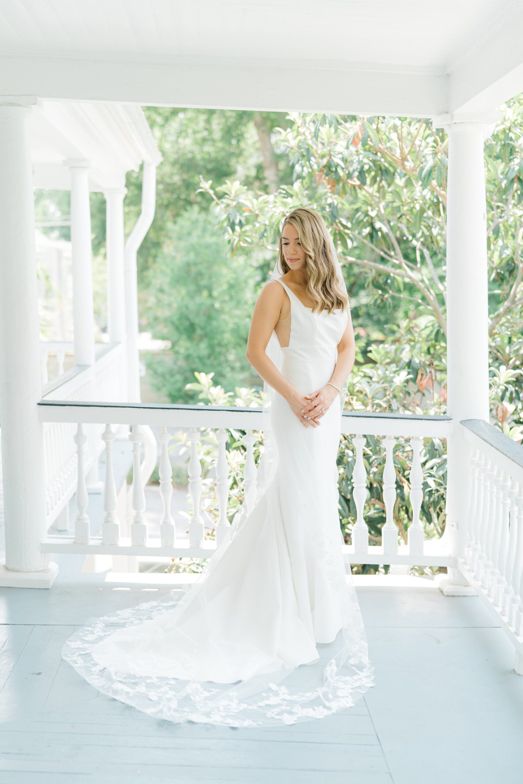 Bride standing on porch on the morning of her wedding.