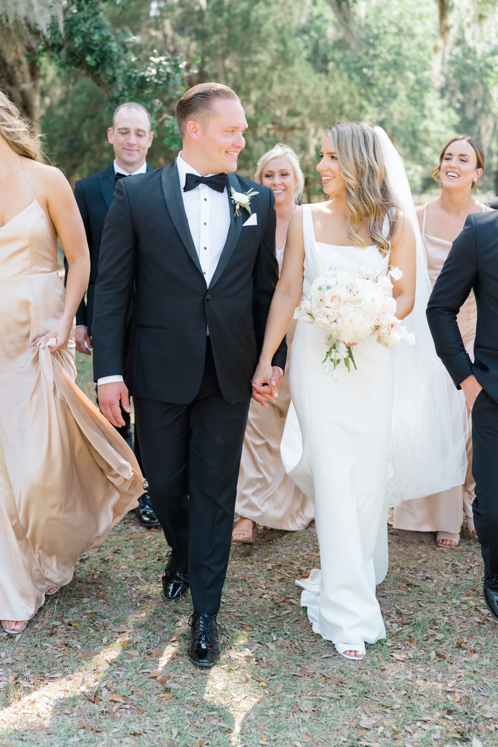 Bride and groom walk with bridal party at Charleston spring wedding.