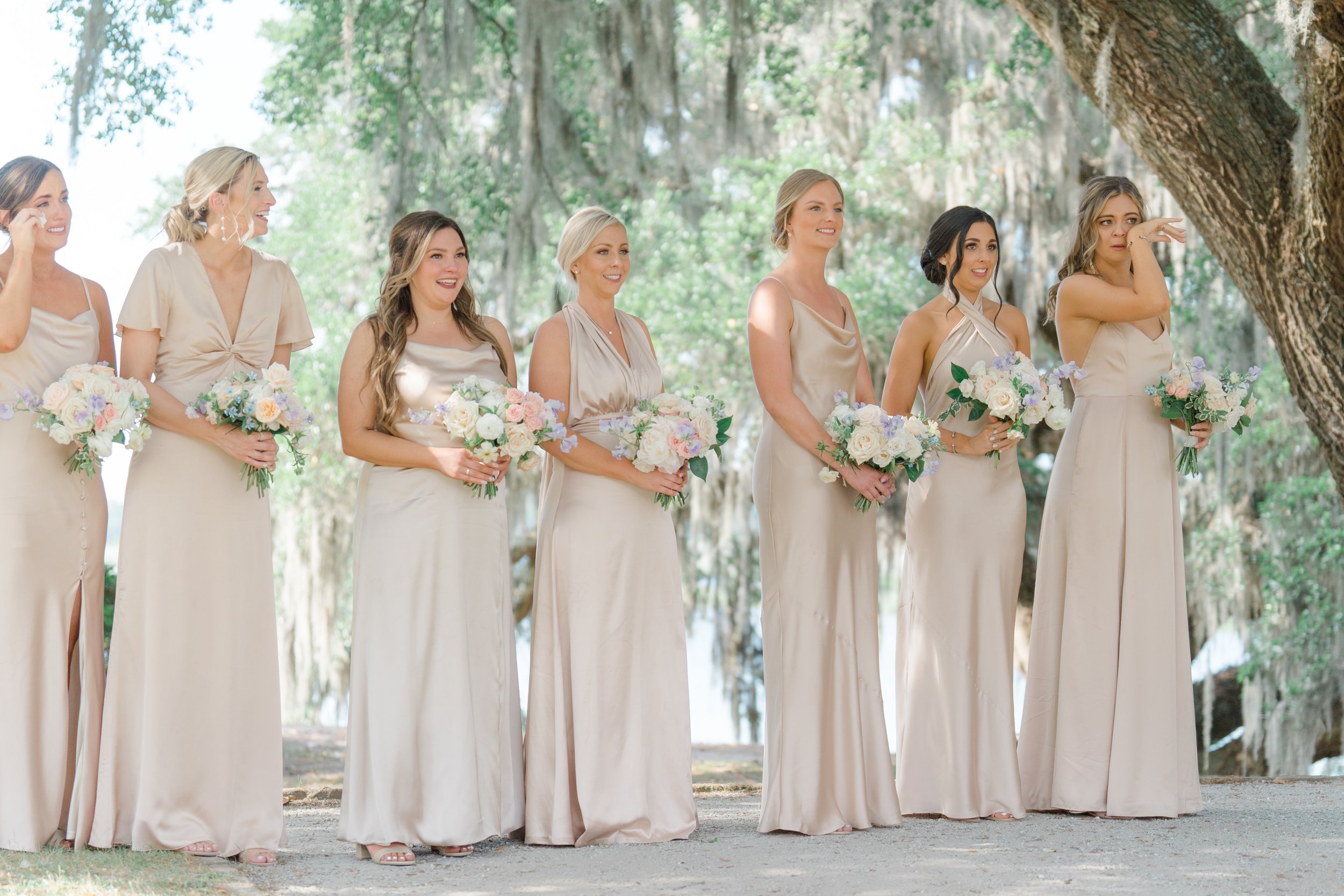 Happy and emotional bridesmaids in champagne dresses at wedding ceremony.