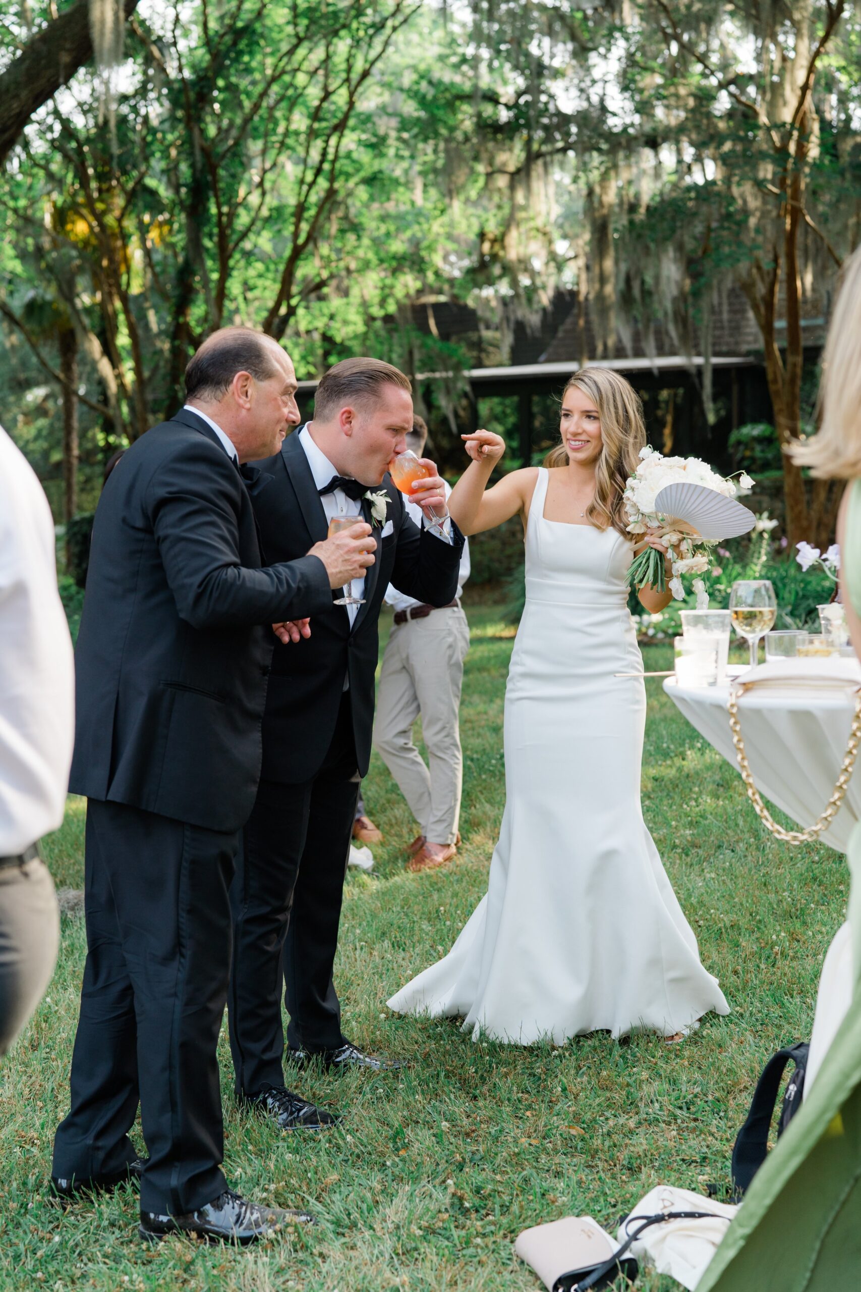 Fun moment with bride, groom, and father of the bride at Crane Pond cocktail hour. Charleston wedding photographer.