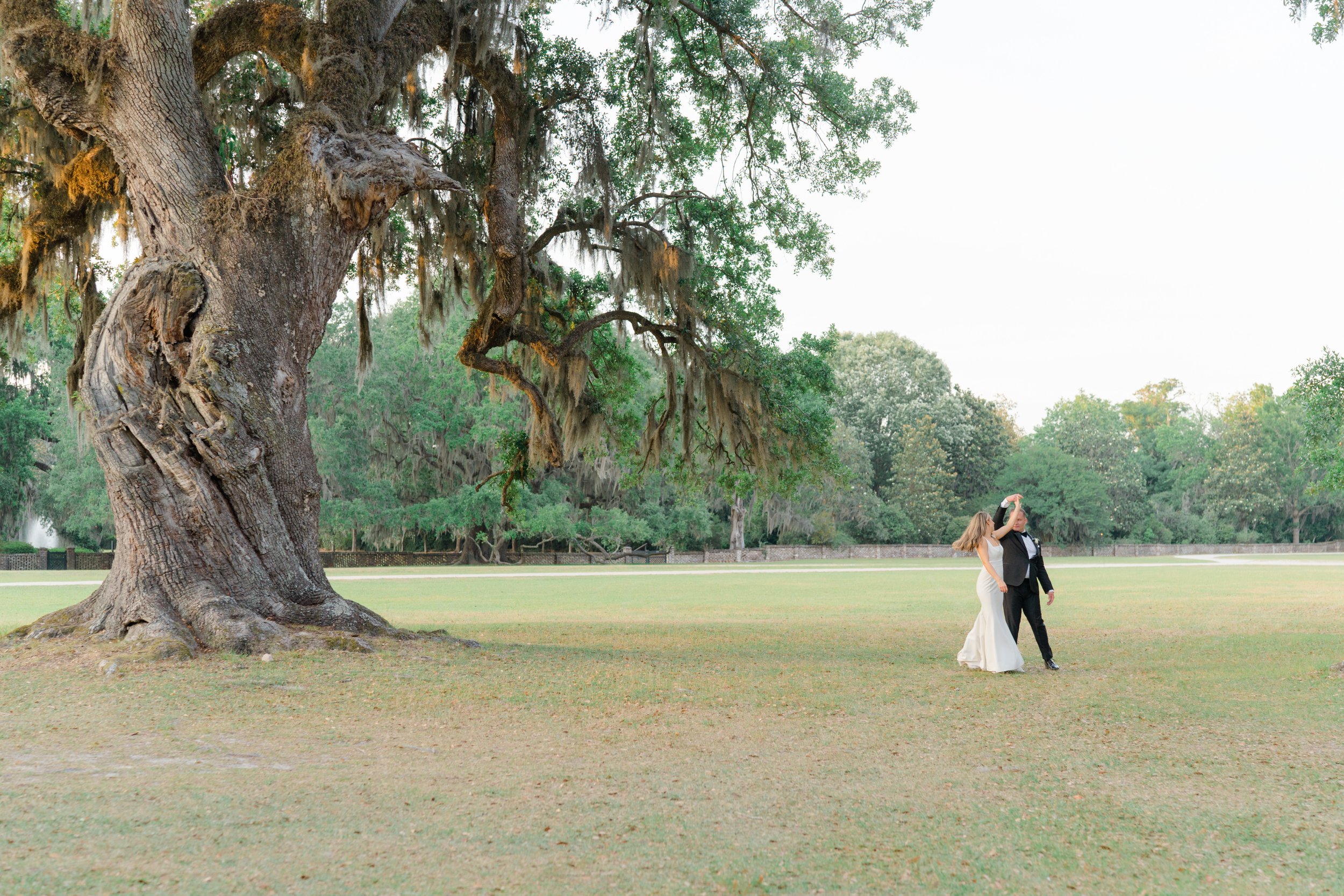 Middleton Place bride and groom dancing in field with old live oak tree