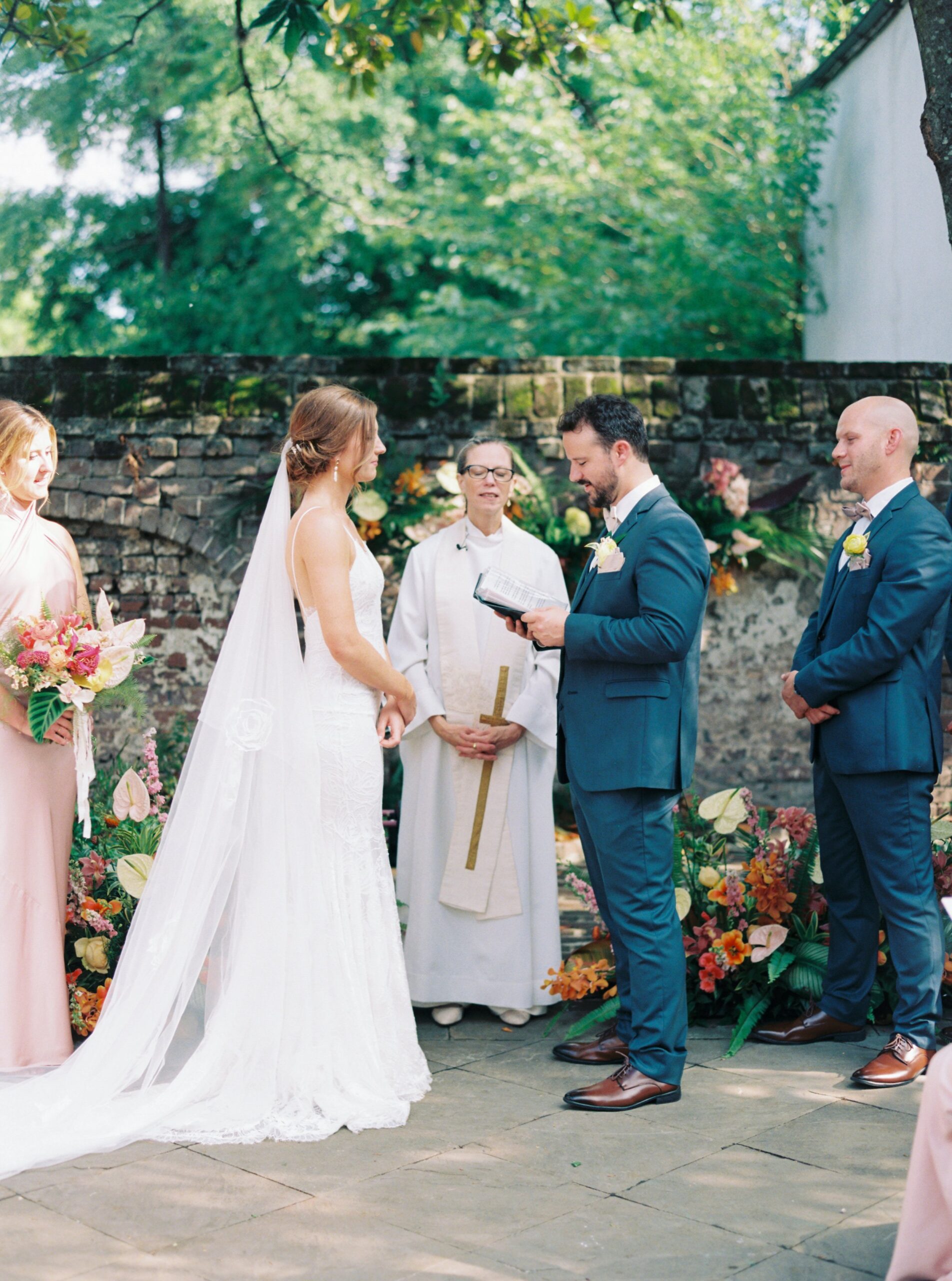 Groom reads vows to bride during outdoor wedding.
