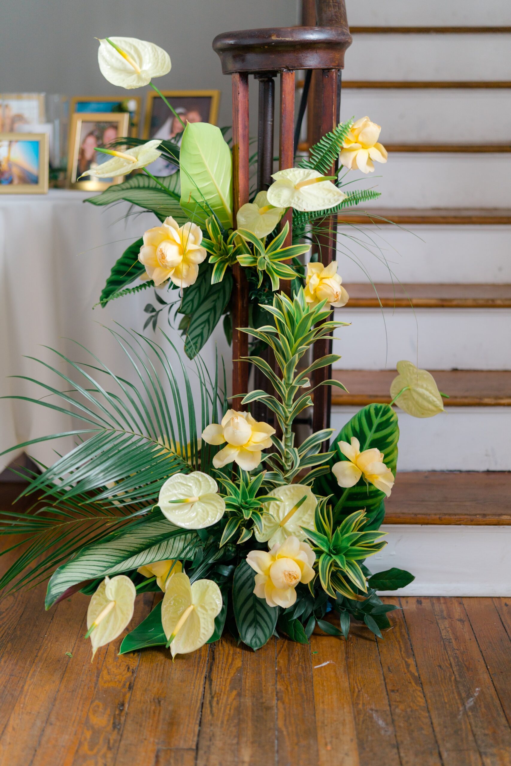 Gadsden House staircase decorated with yellow tropical flowers and greenery.