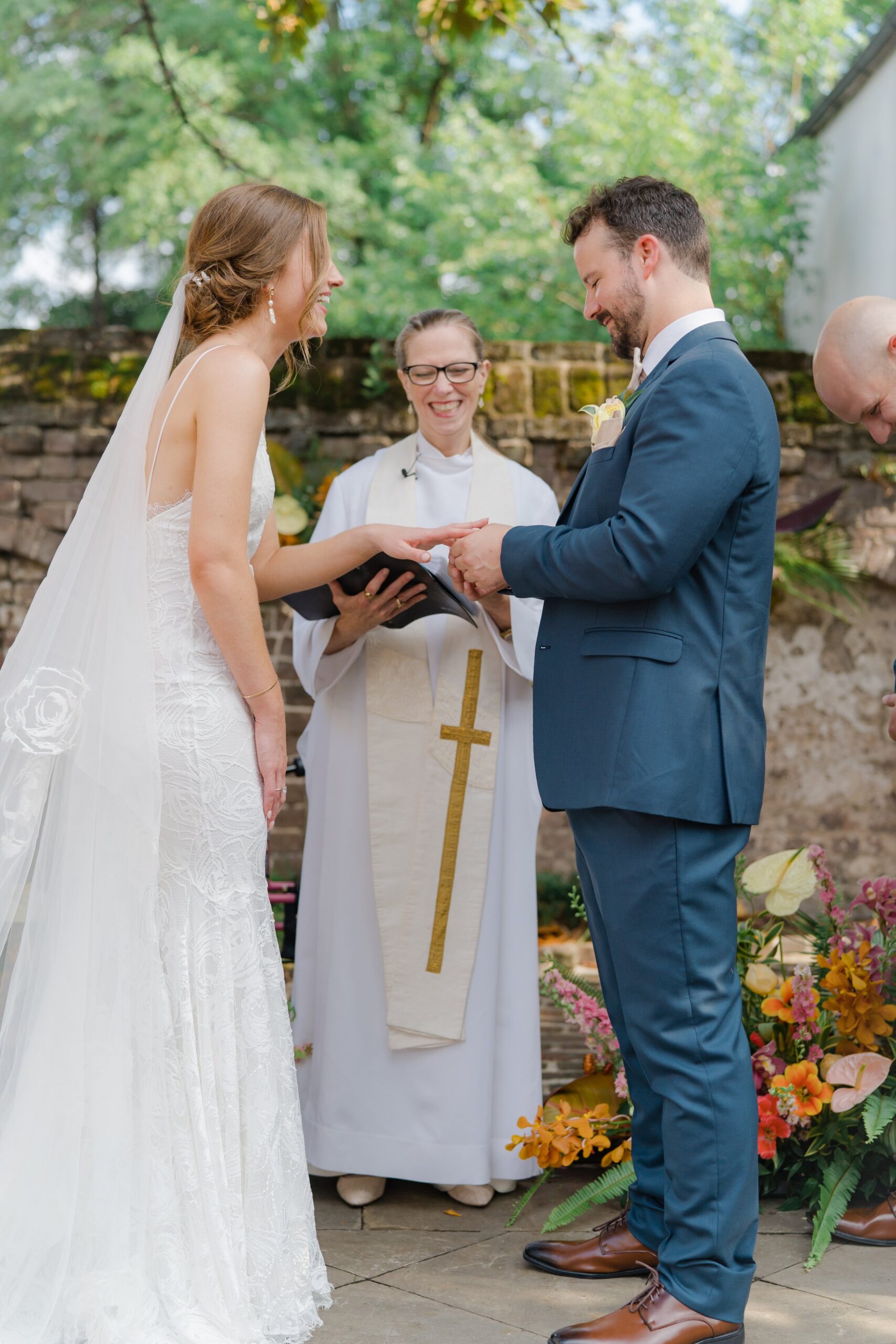 Groom puts ring on Bride during wedding ceremony.