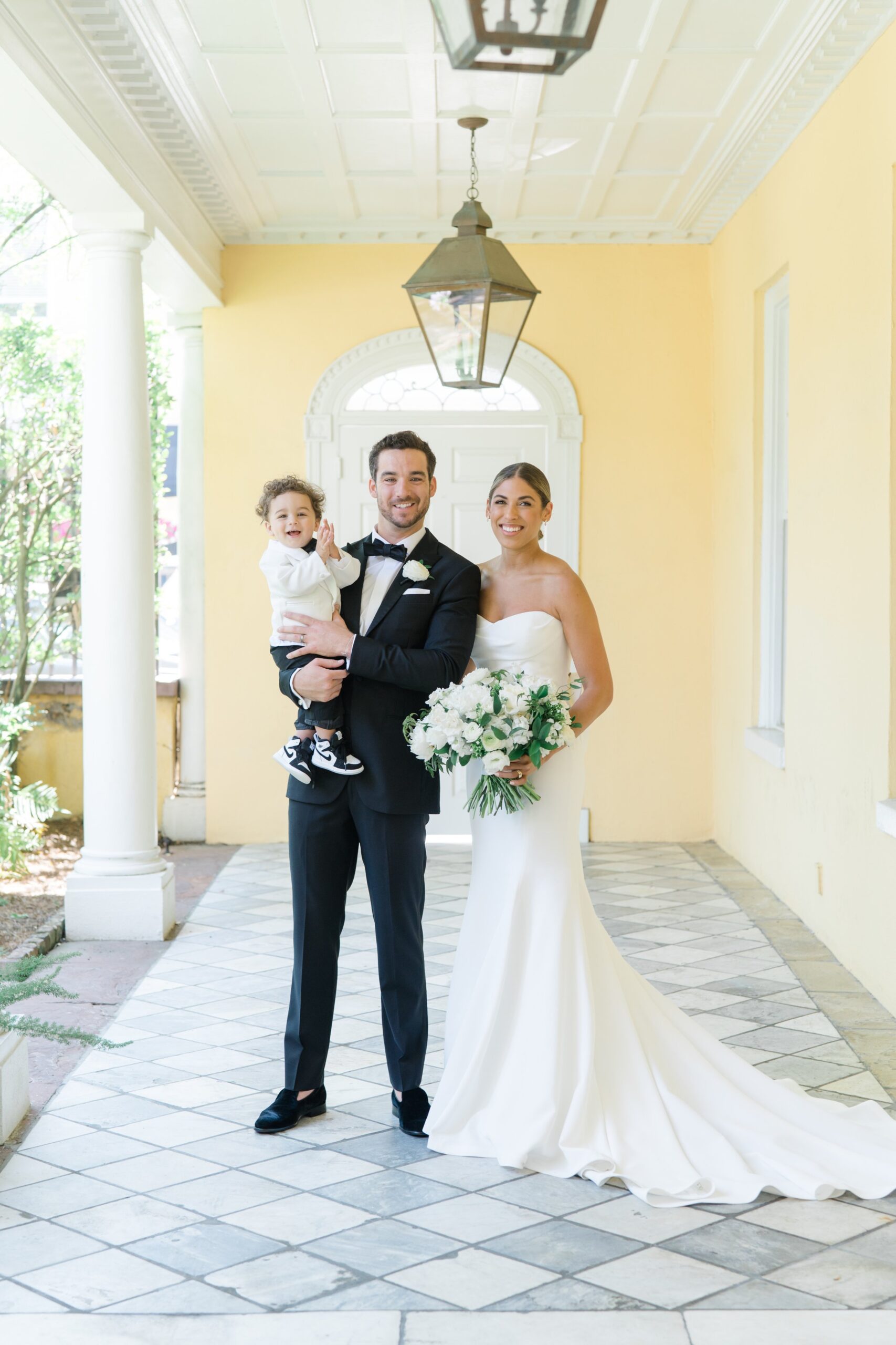 Bride and groom with son on wedding day.