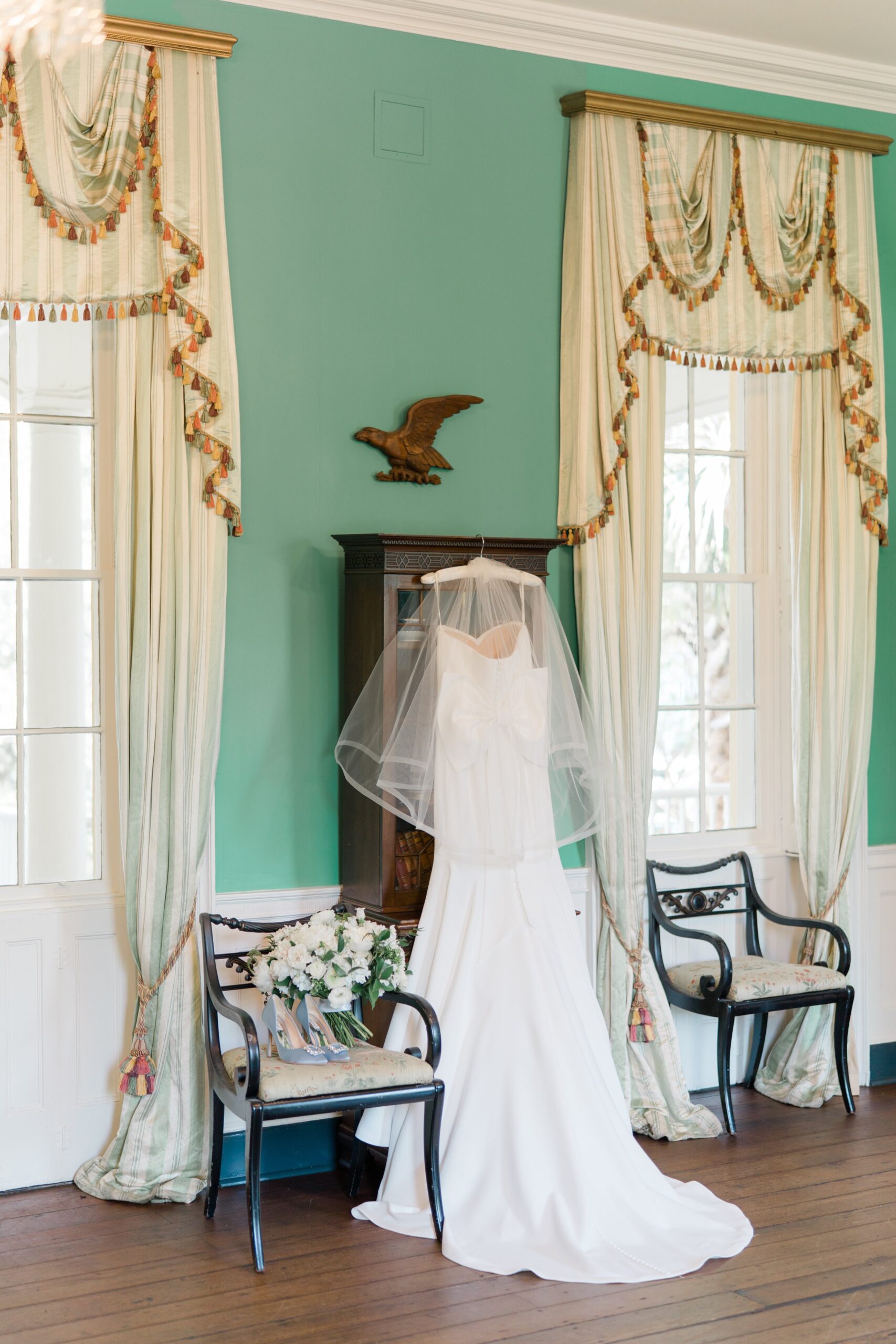 wedding dress, flowers and heels hanging in historic Charleston wedding venue.