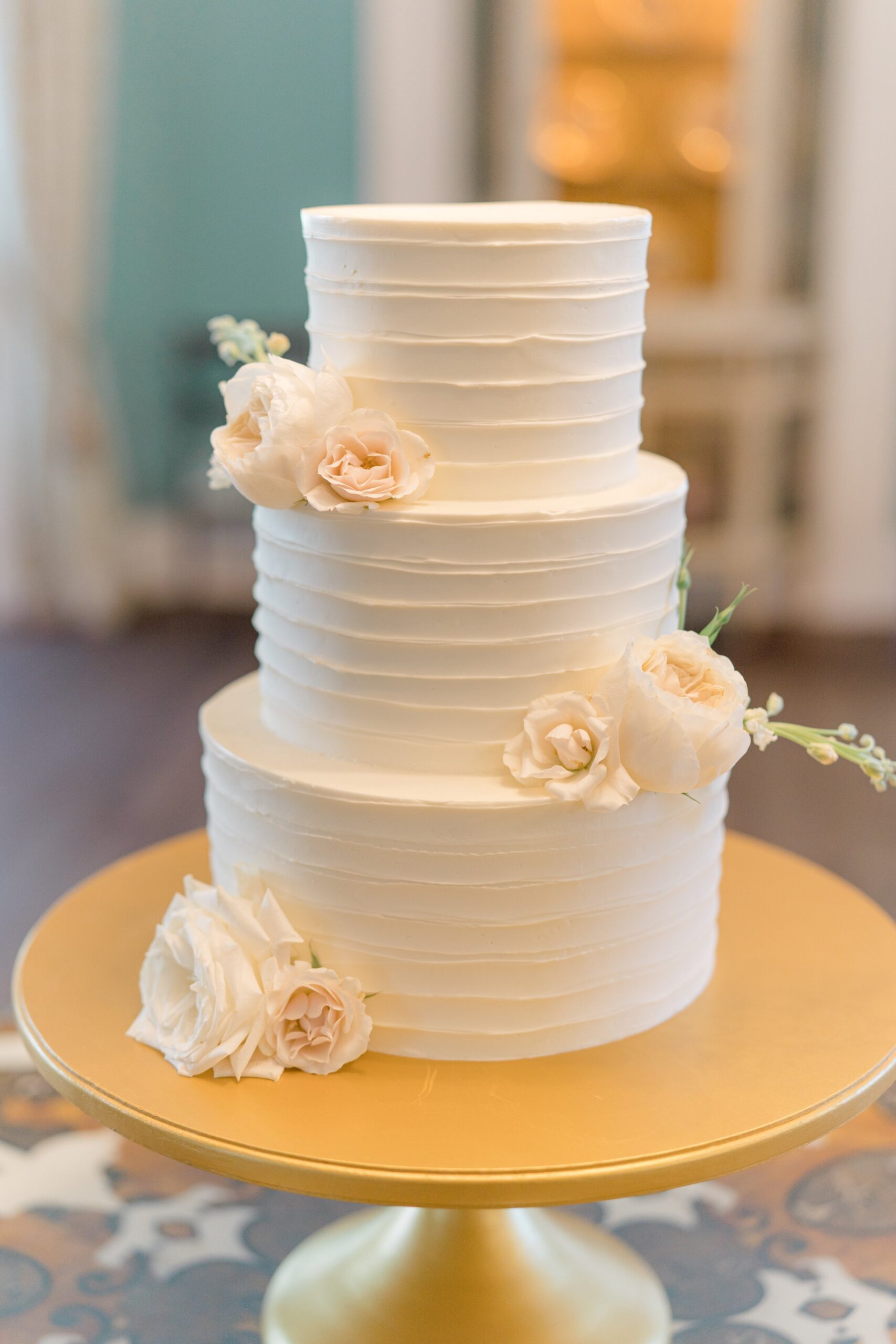 Charleston wedding cake with simple white flowers.