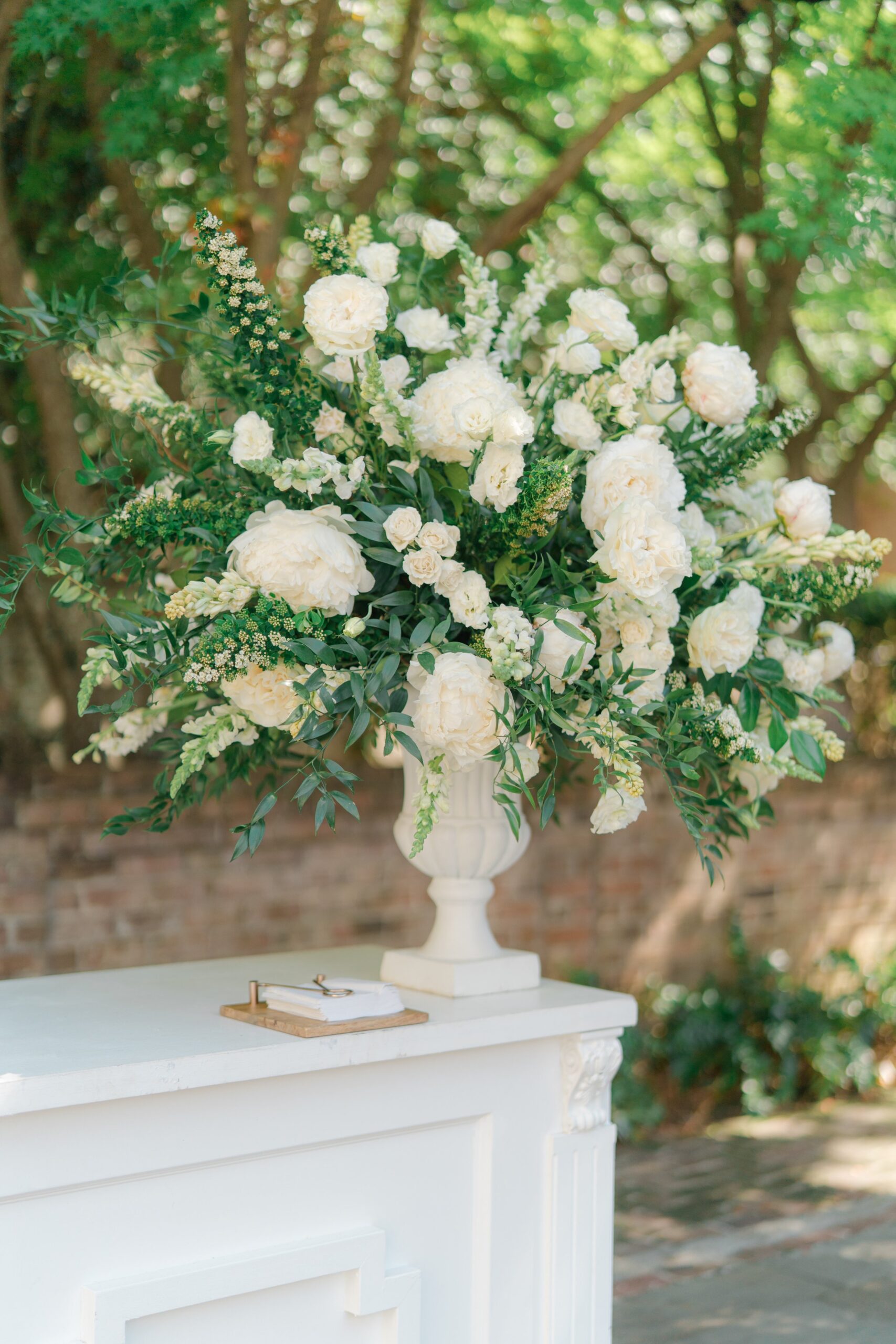 Oversized white and green pedestal flowers on reception bar.