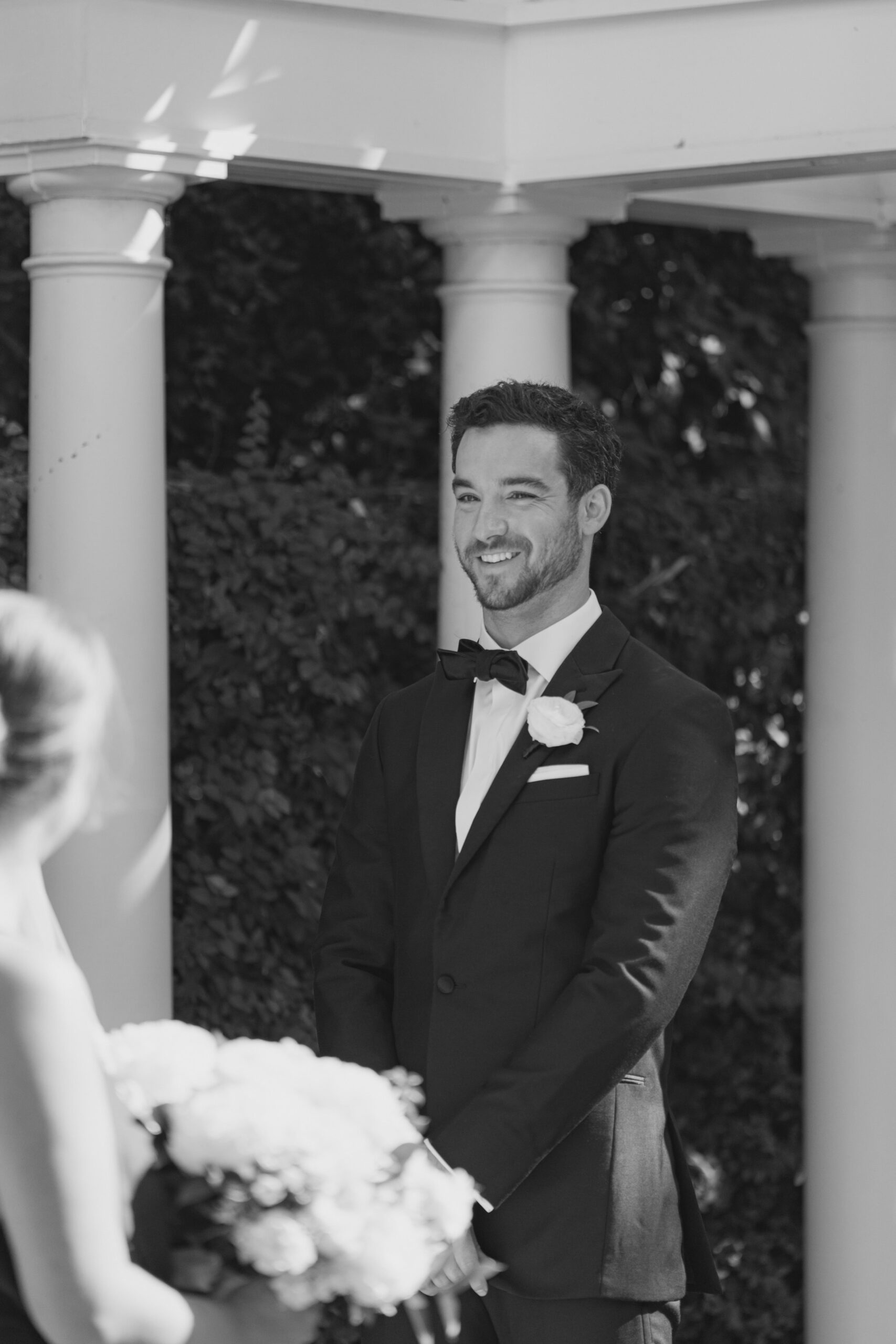 Groom black and white wedding ceremony photo.