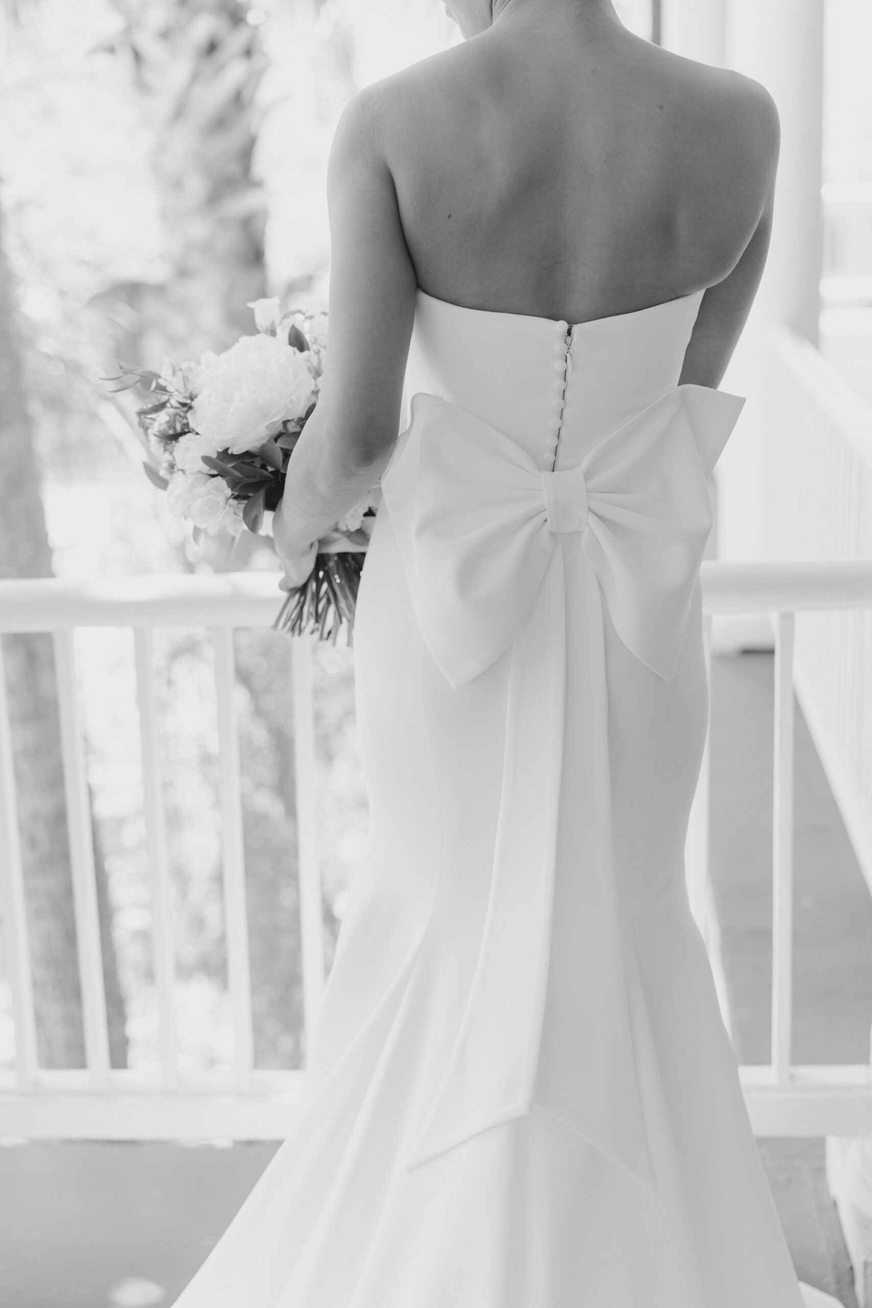 Black and white wedding photo. Big bow on back on vera wang wedding dress.