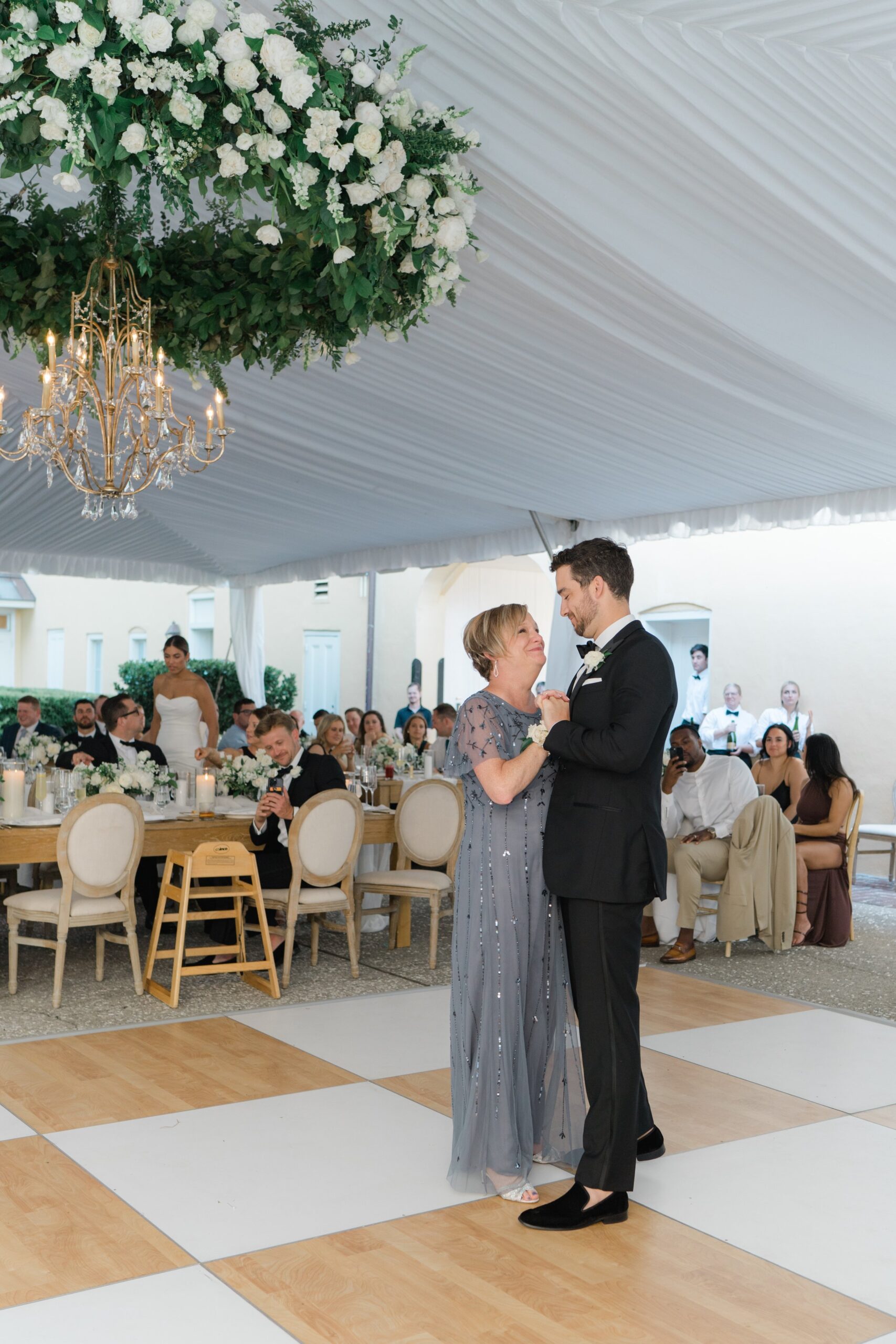 Groom and mom dance at spring Charleston outdoor wedding reception.