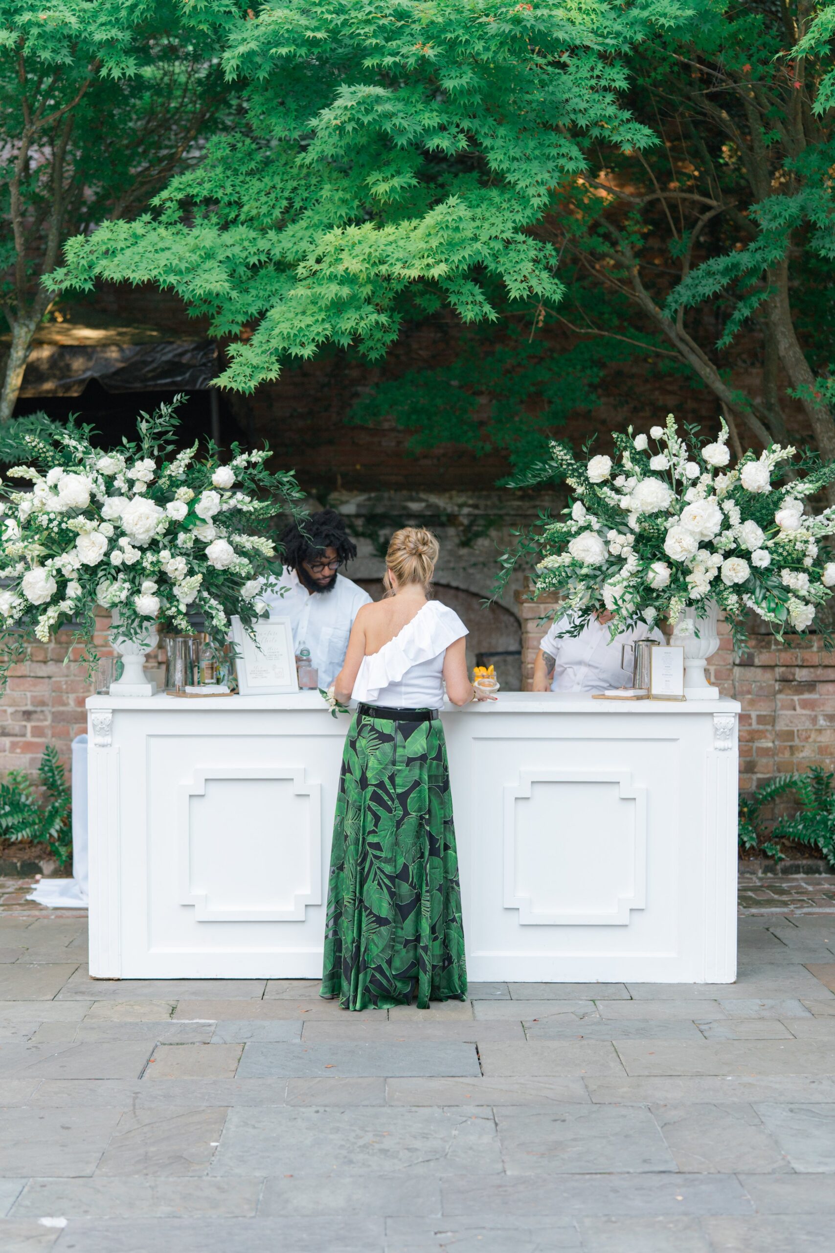 William Aiken House outdoor wedding reception bar with oversized flowers.