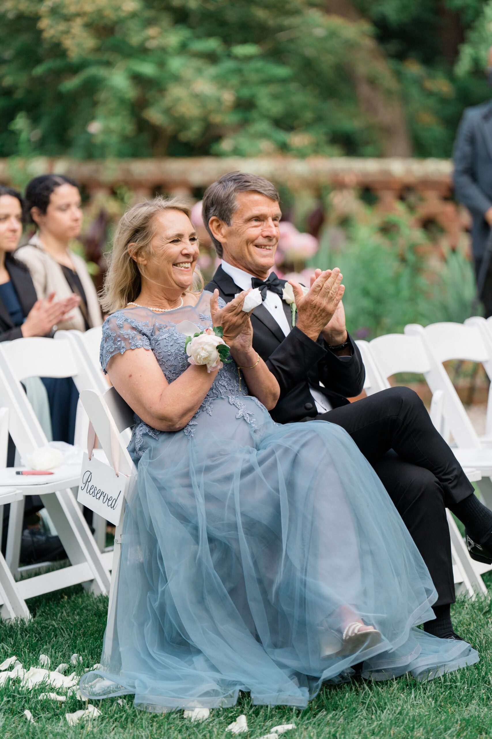 Parents of the groom clap during first kiss at boston summer wedding ceremony.