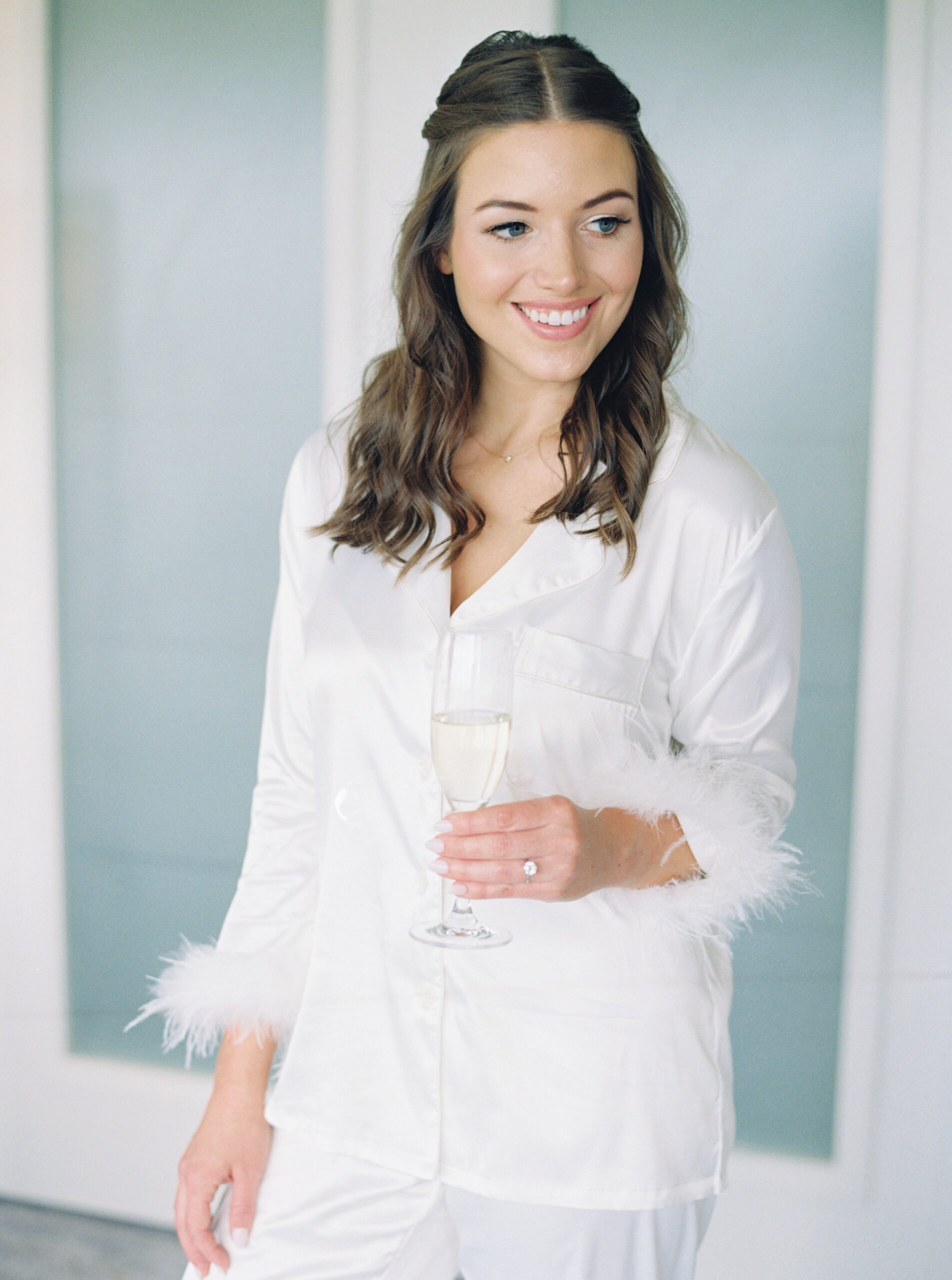 Bride in feather sleeved white long pajamas on the morning of her wedding at the Ritz Carlton in Boston