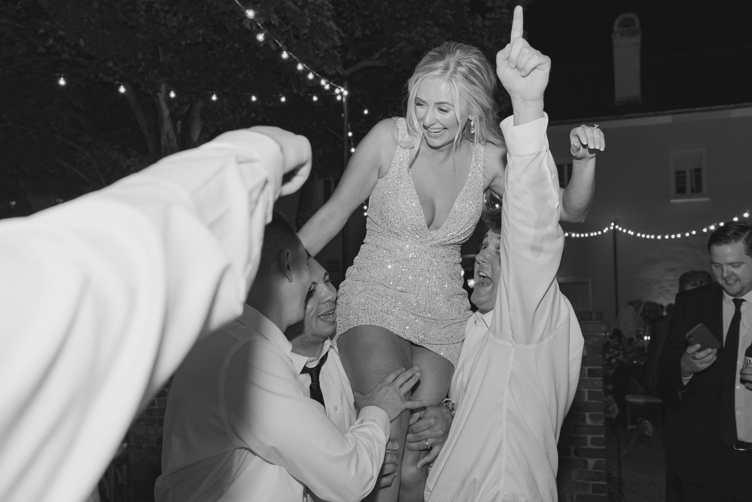 bride in second dress gets picked up by wedding party on the dance floor.