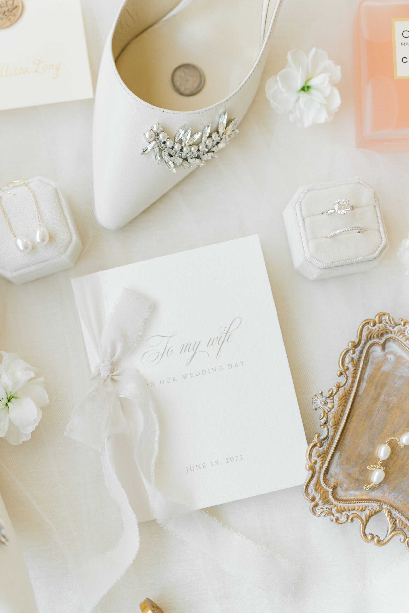 neutral toned wedding day details. Vow book with large bow and jimmy choo heels .