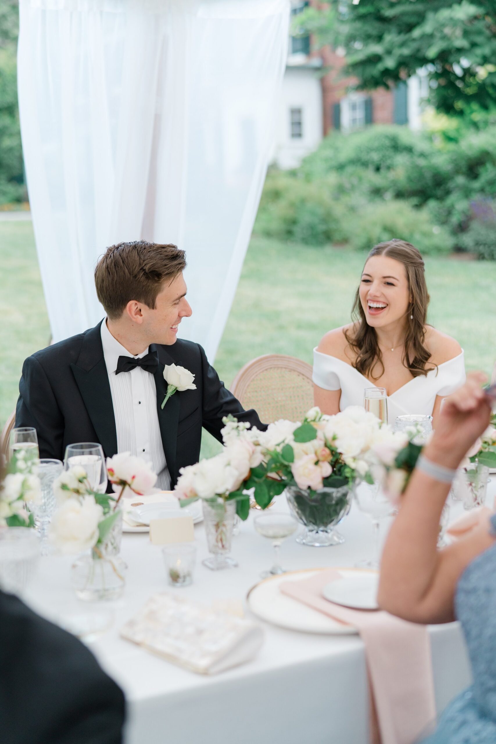 happy bride laughs during maid of honor speech.