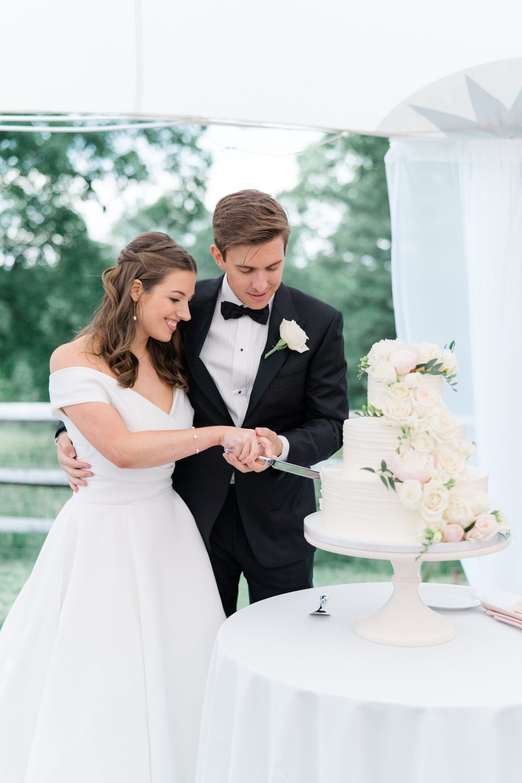 bride and groom cute wedding cake overflowing with flowers.