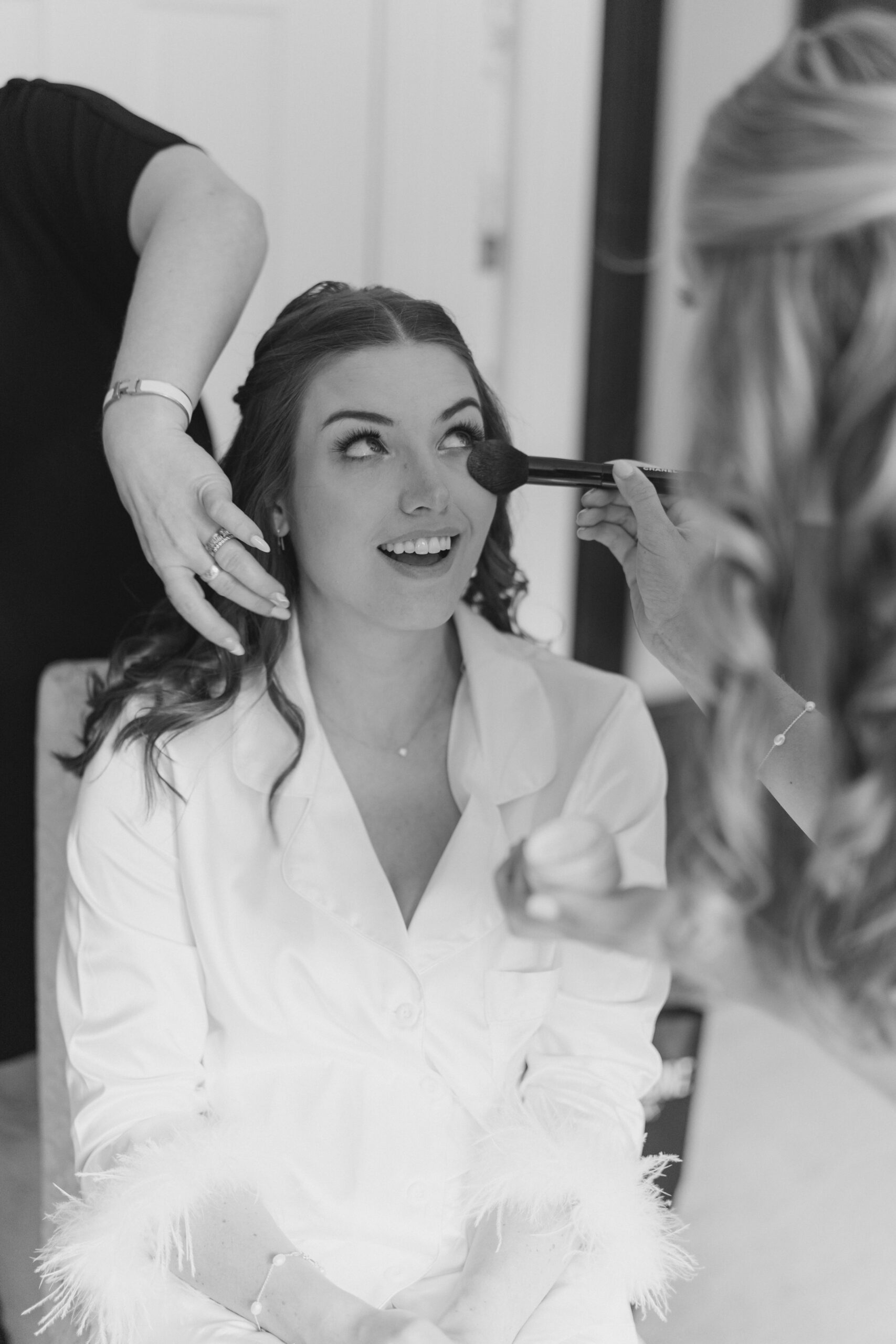 Bride gets final touch ups before putting on her wedding dress for summer wedding in Boston