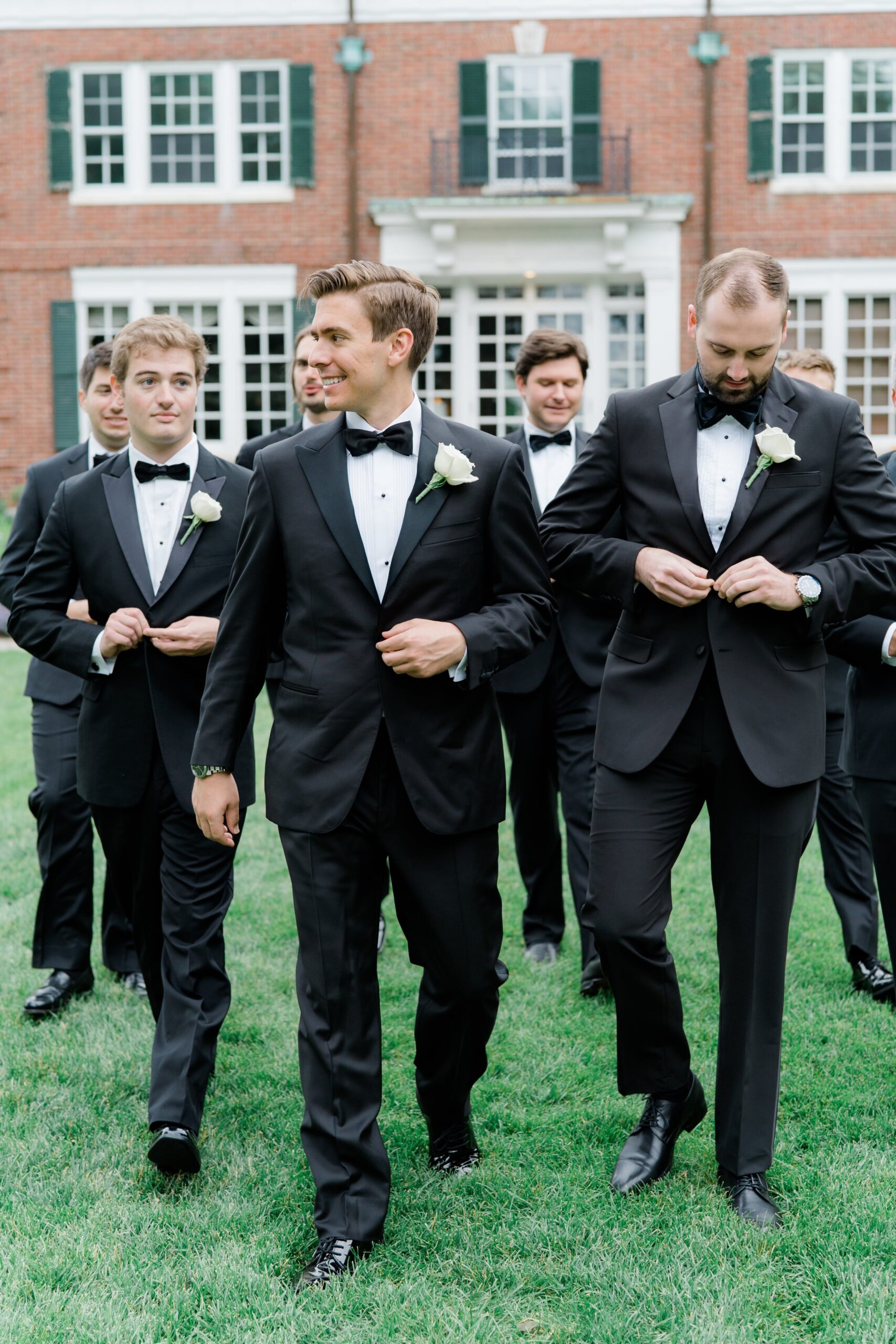 GQ black tie groom walks with groomsmen at Bradley Estate summer wedding.