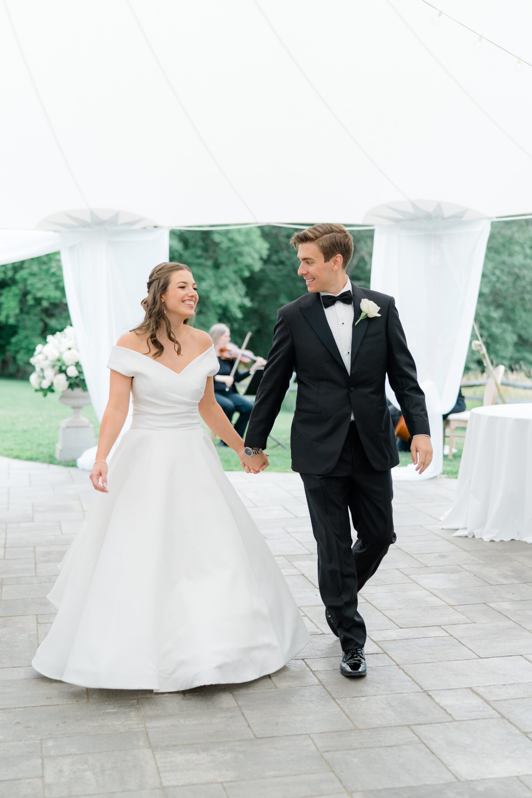 Bride and groom walk to first dance at boston summer wedding.