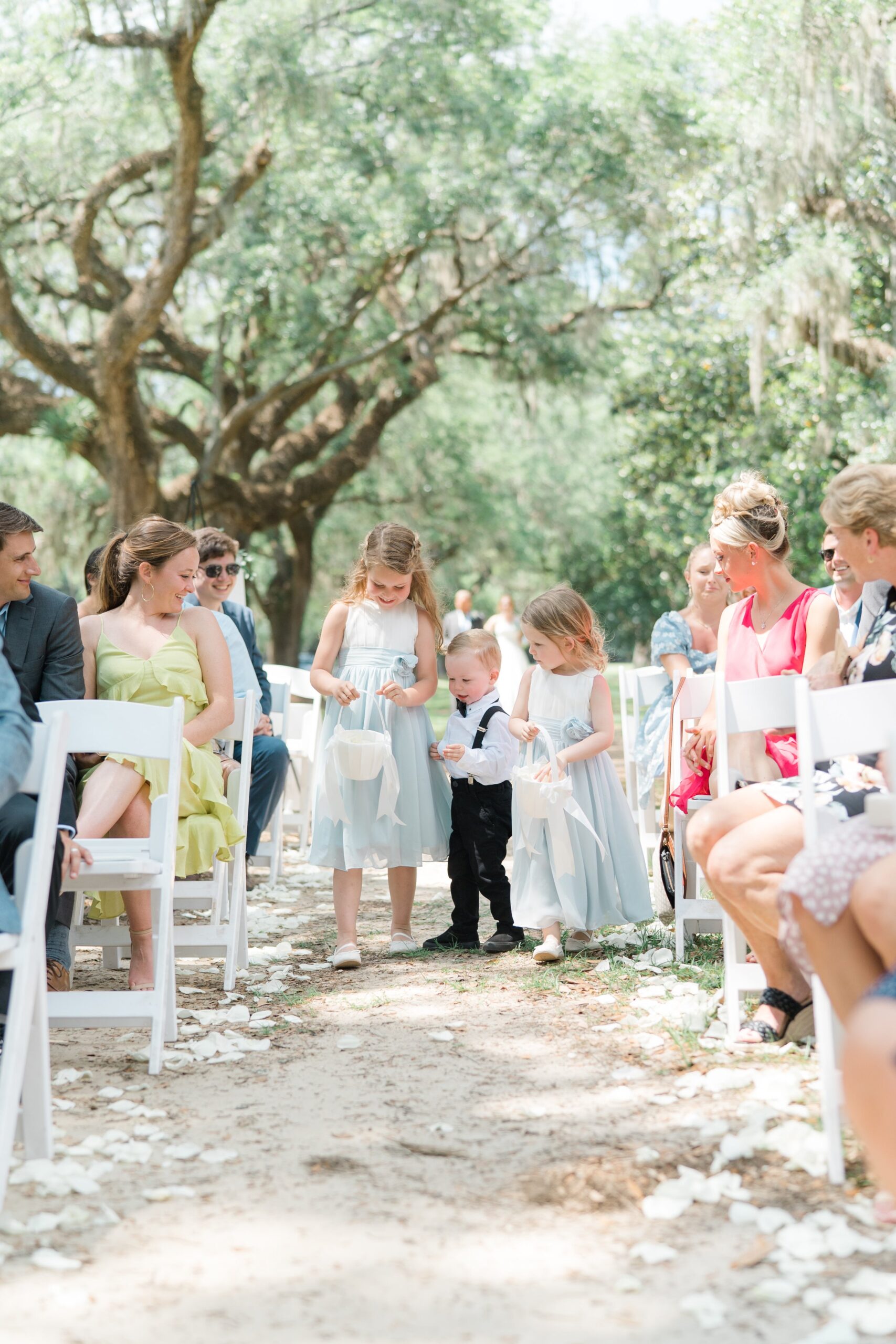 cute flower girls walk with the aisle with help