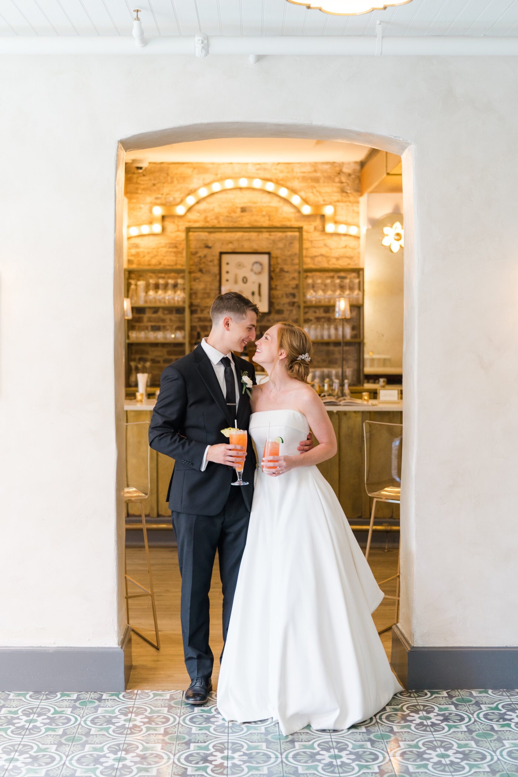 bride and groom with custom cocktails at spring wedding reception in downtown Charleston.