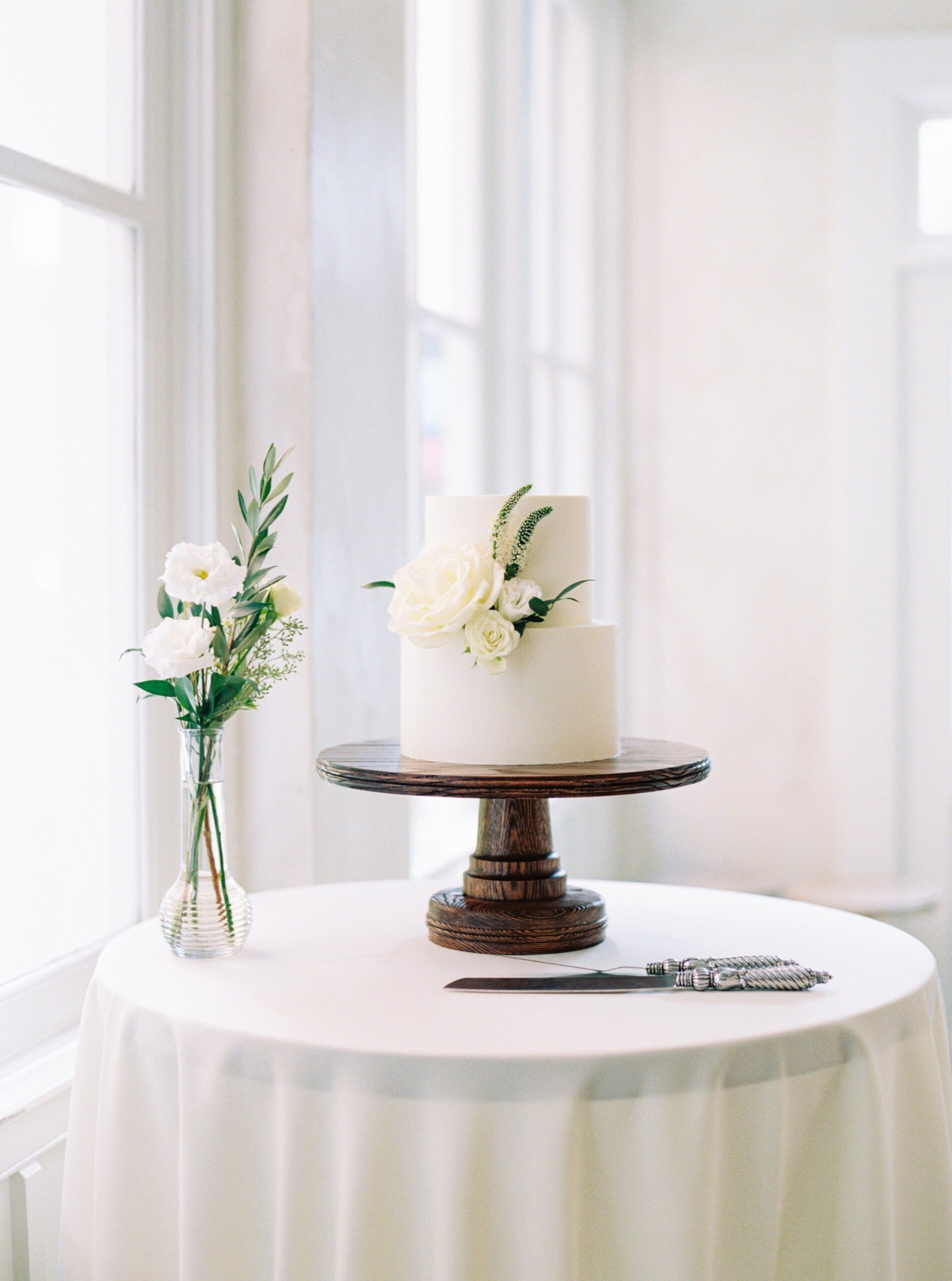 simple white wedding cake with beautiful flowers and greenery. Charleston wedding photographer.