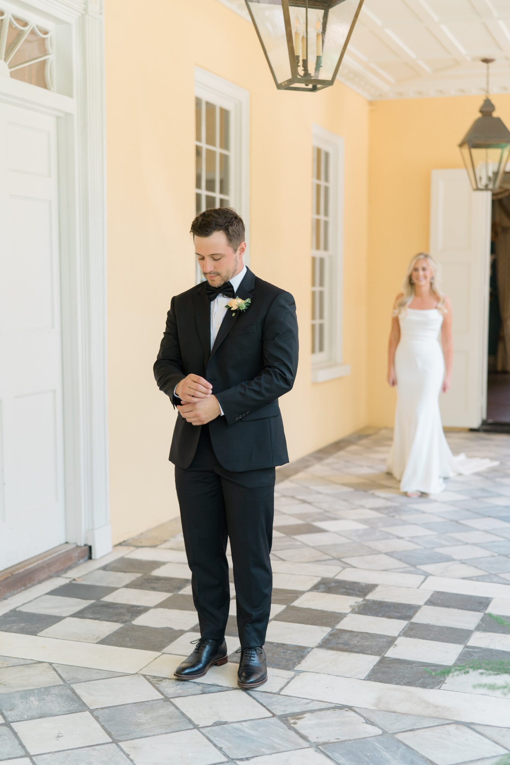nervous emotional groom makes sure everything is perfect while bride walks up to see him for the first time
