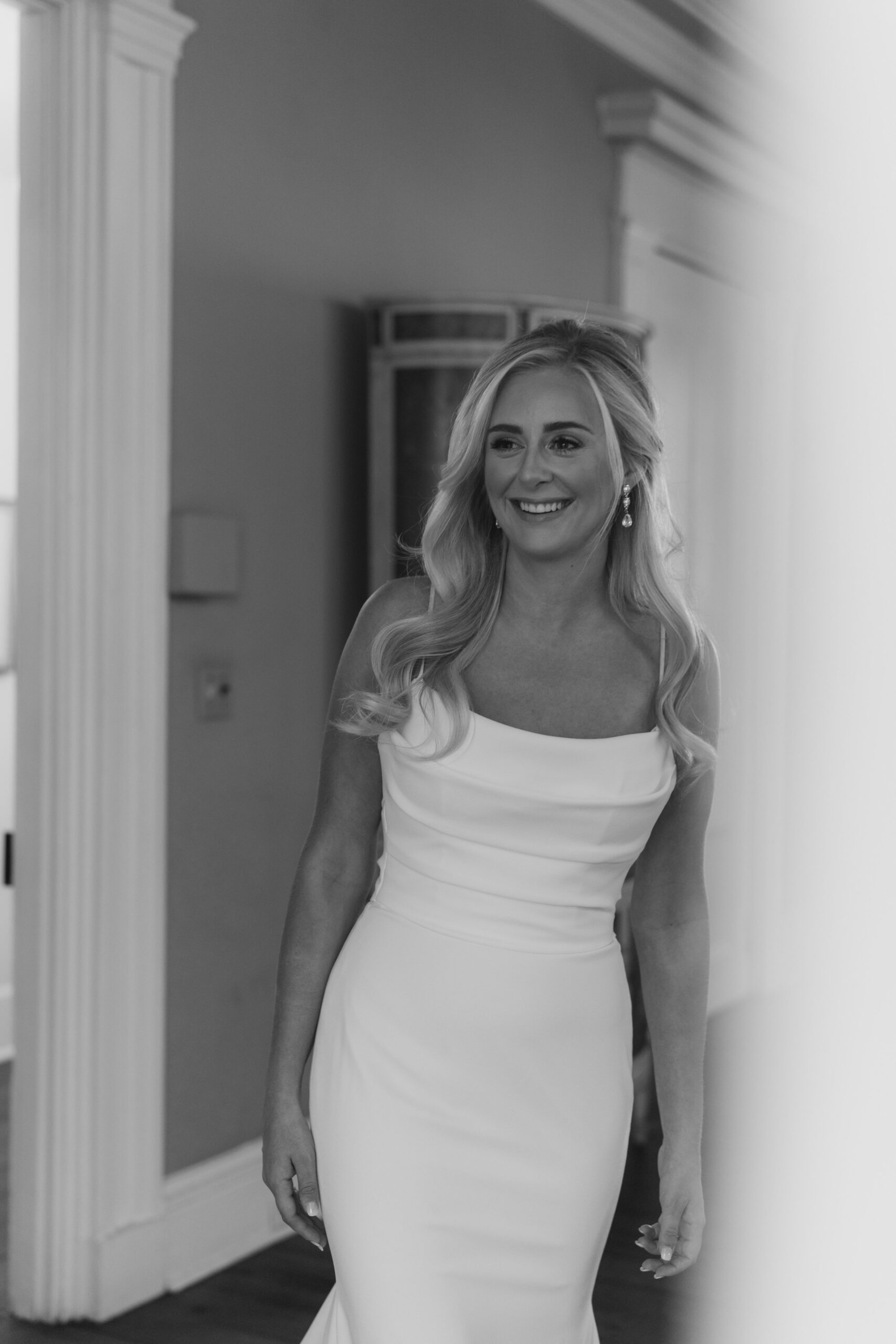 smiling bride heads to first look. black and white wedding photo