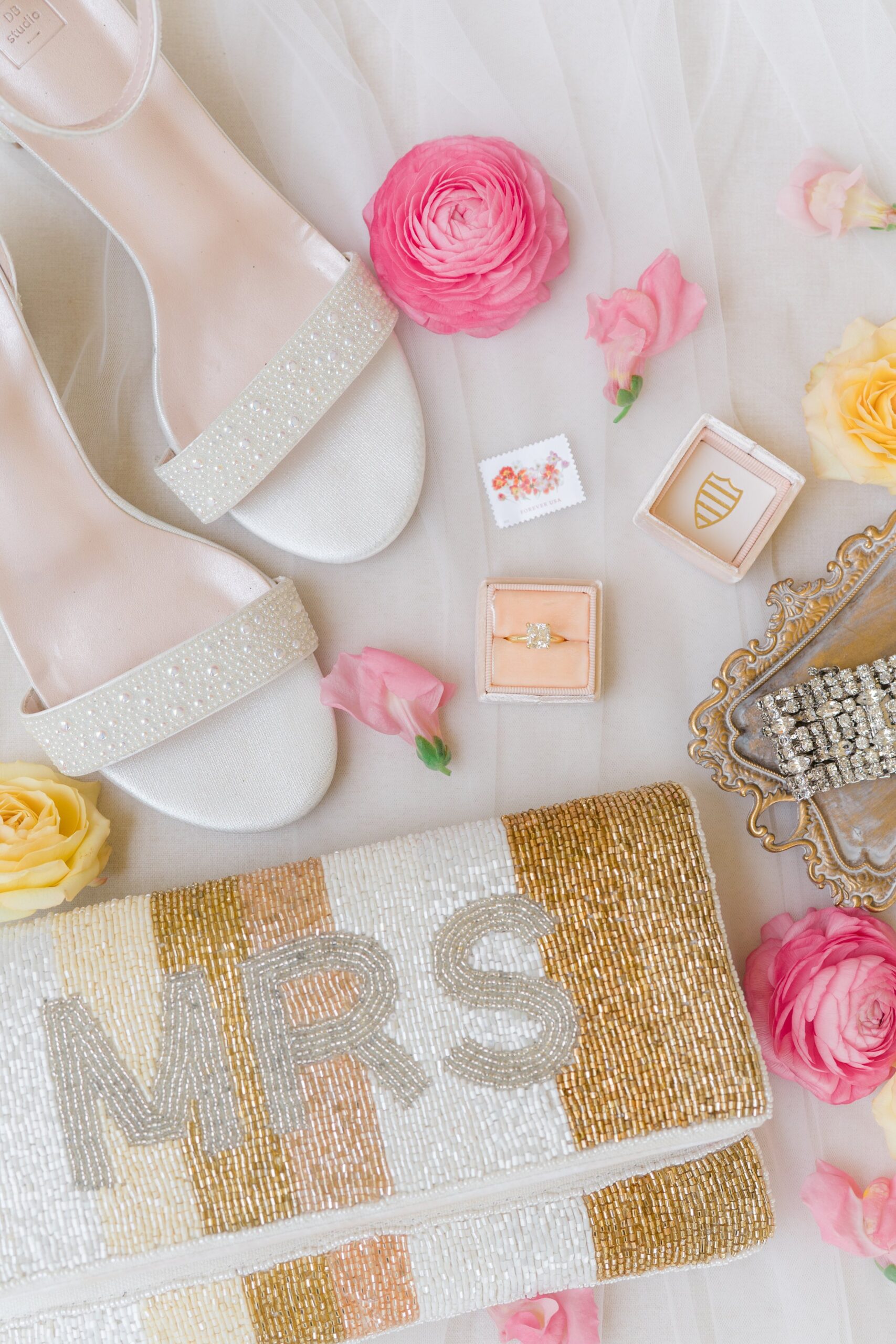 bride details with pink flowers and mrs. clutch purse