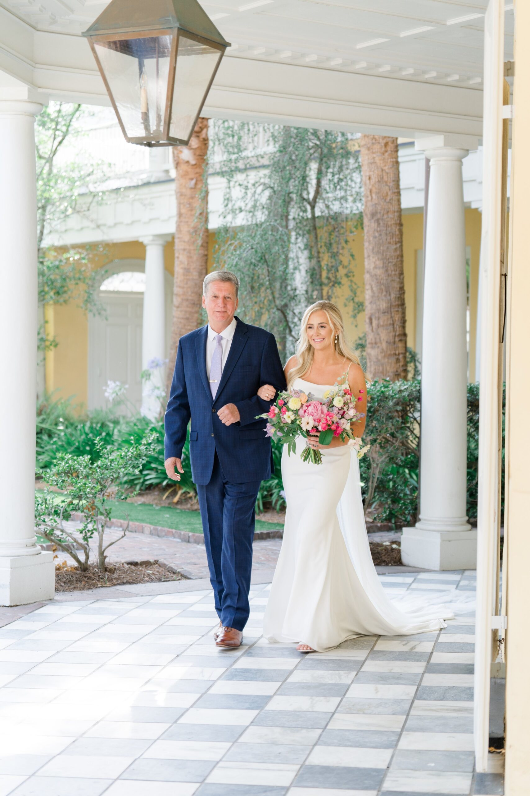 bride and dad walk to spring wedding ceremony at william aiken house.