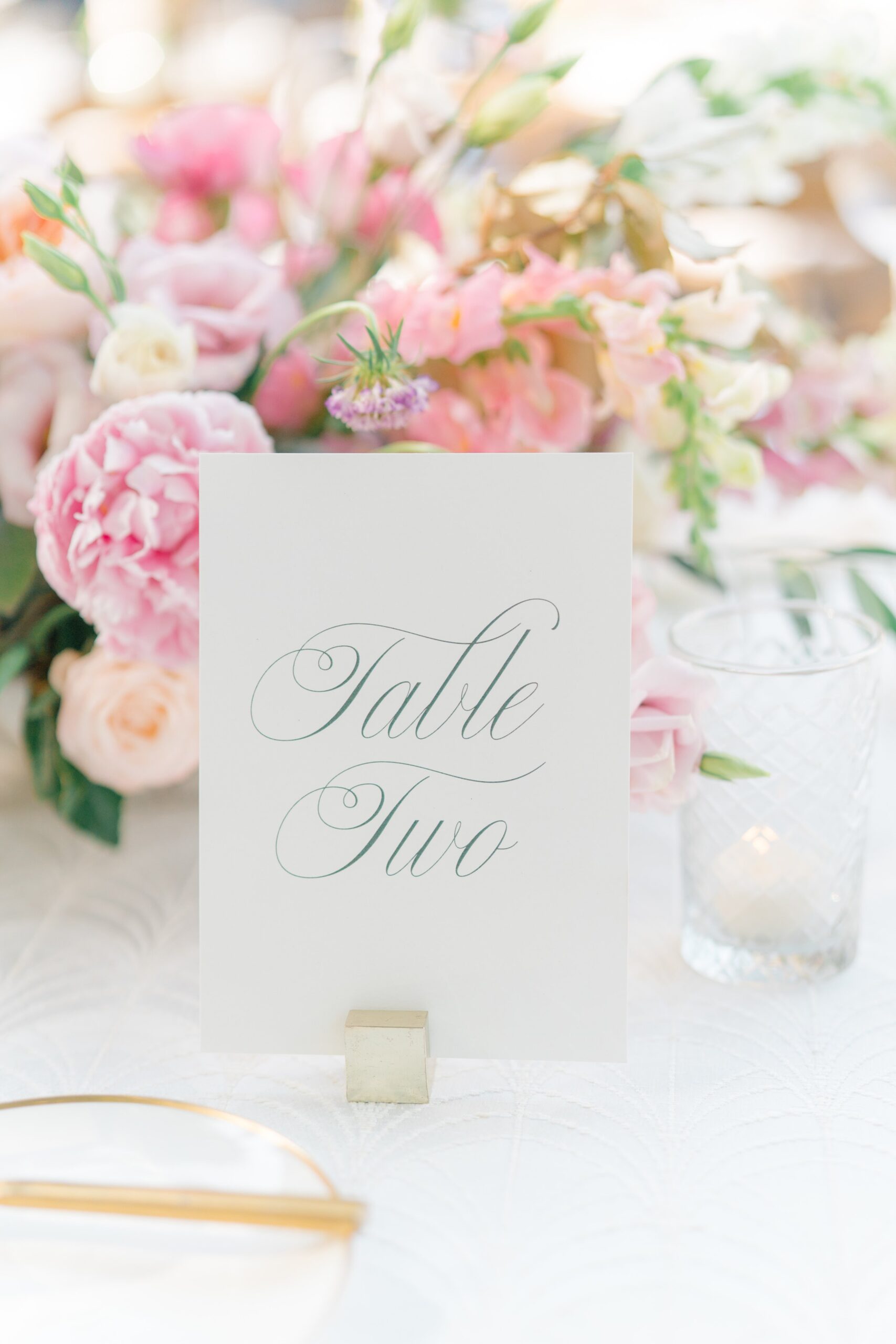 script table numbers and pink flowers. garden party outdoor reception